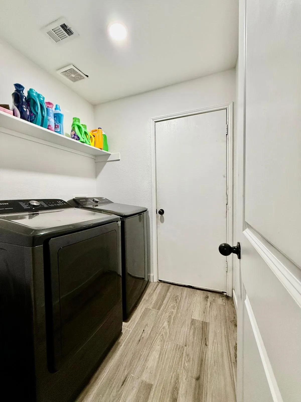 Wood-finish flooring with white walls and a built-in shelf