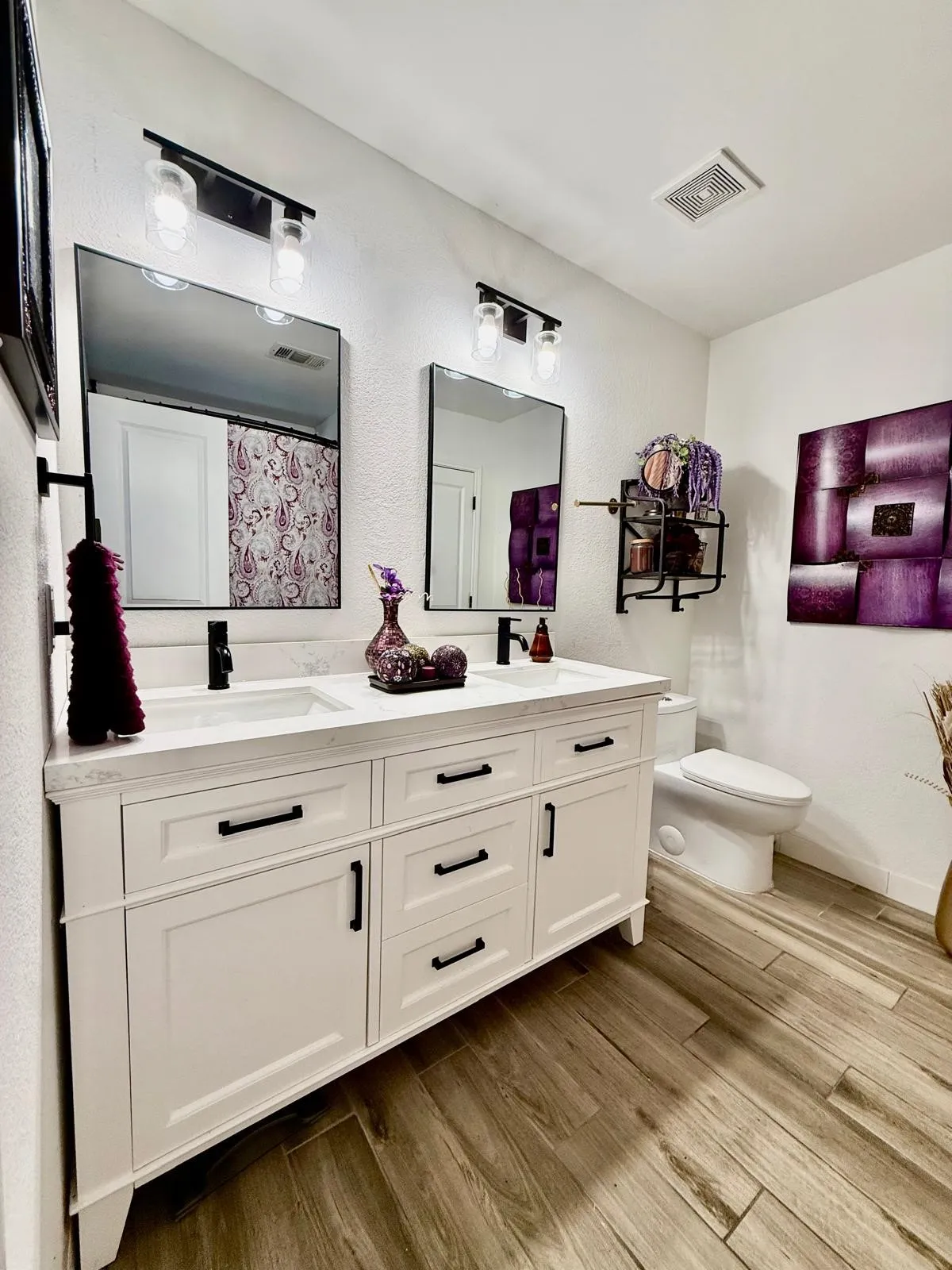 Dual vanity with white shaker-style cabinetry, dark hardware, and integrated sinks