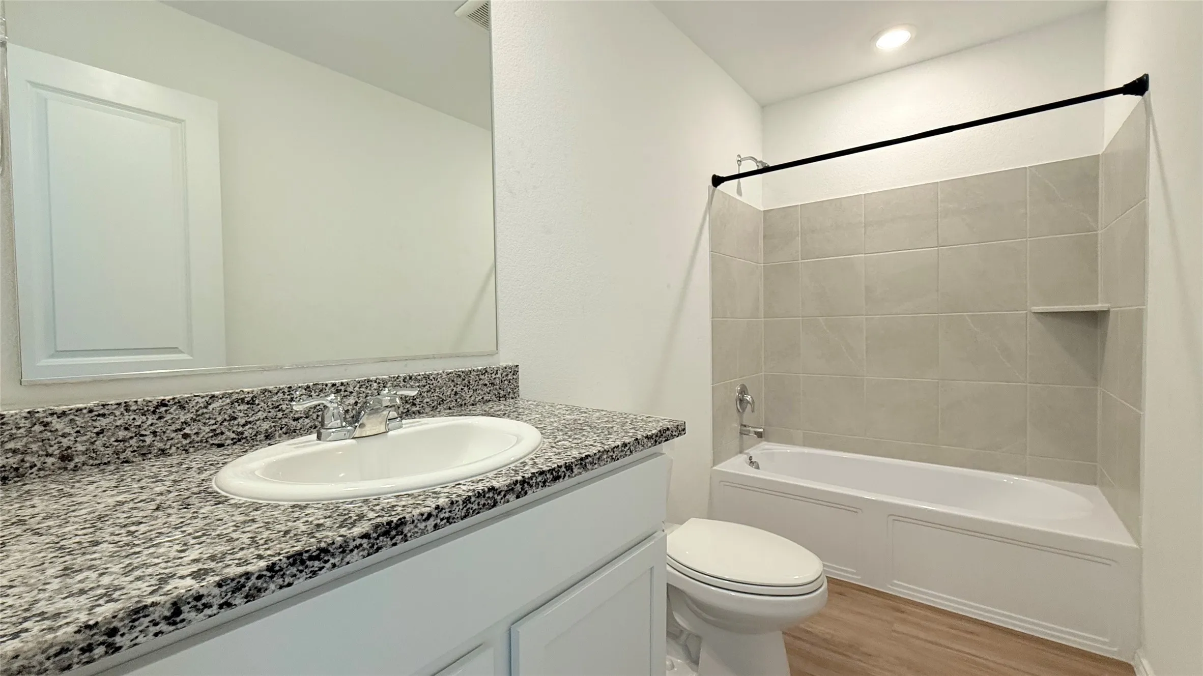 Vanity with granite-style countertop, undermount sink, and chrome faucet