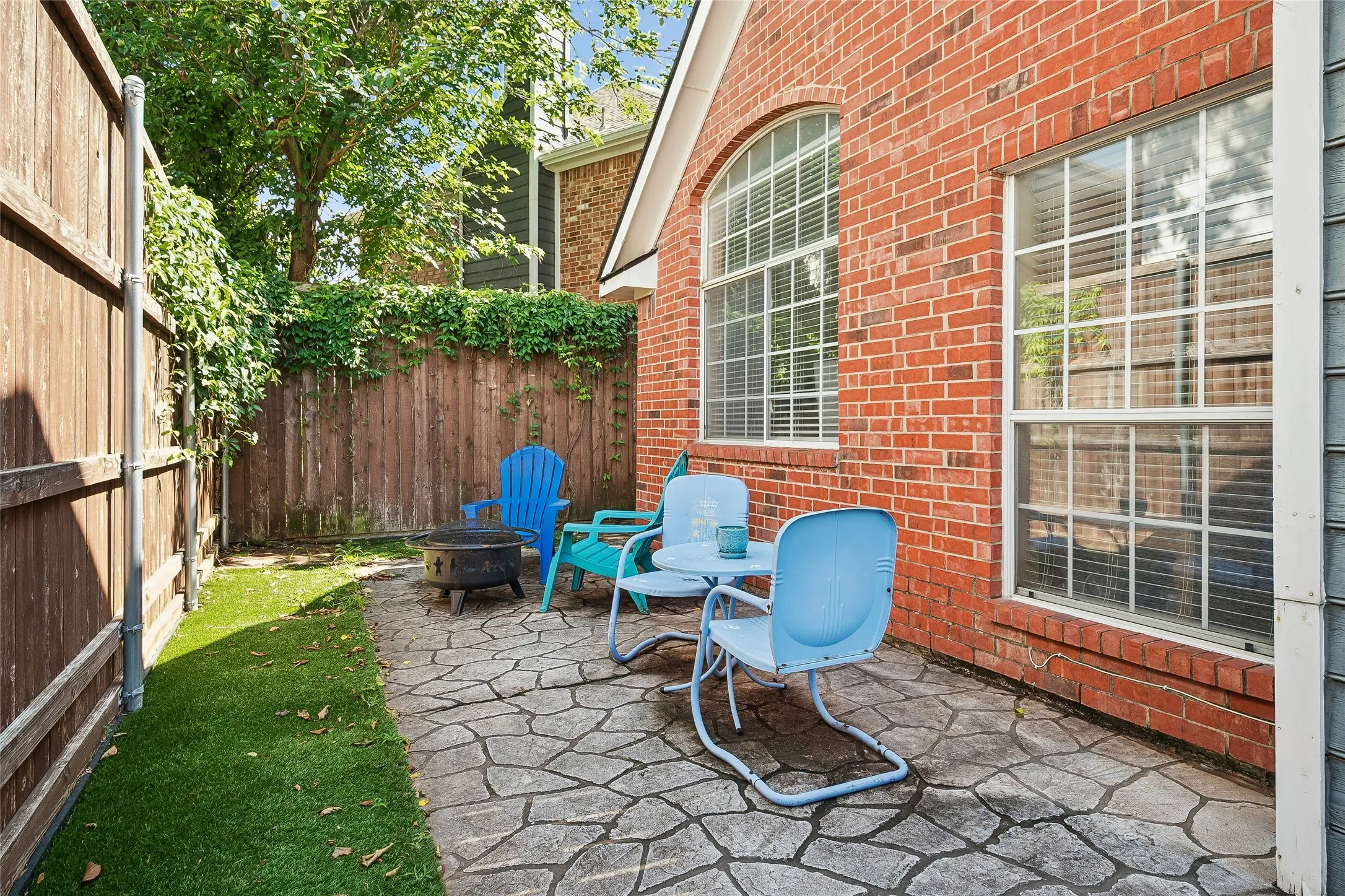 Private outdoor patio featuring flagstone-style paving and an artificial turf area