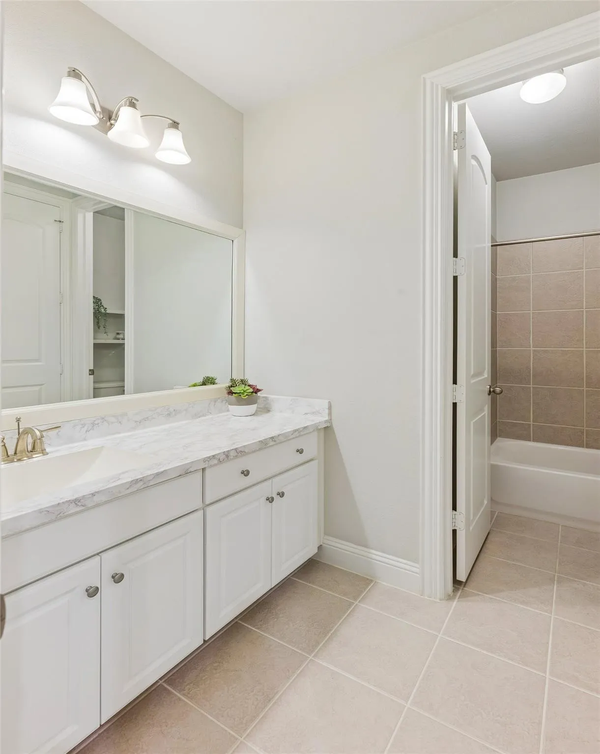 Double vanity with white cabinetry, light-toned countertop, and undermount sinks
