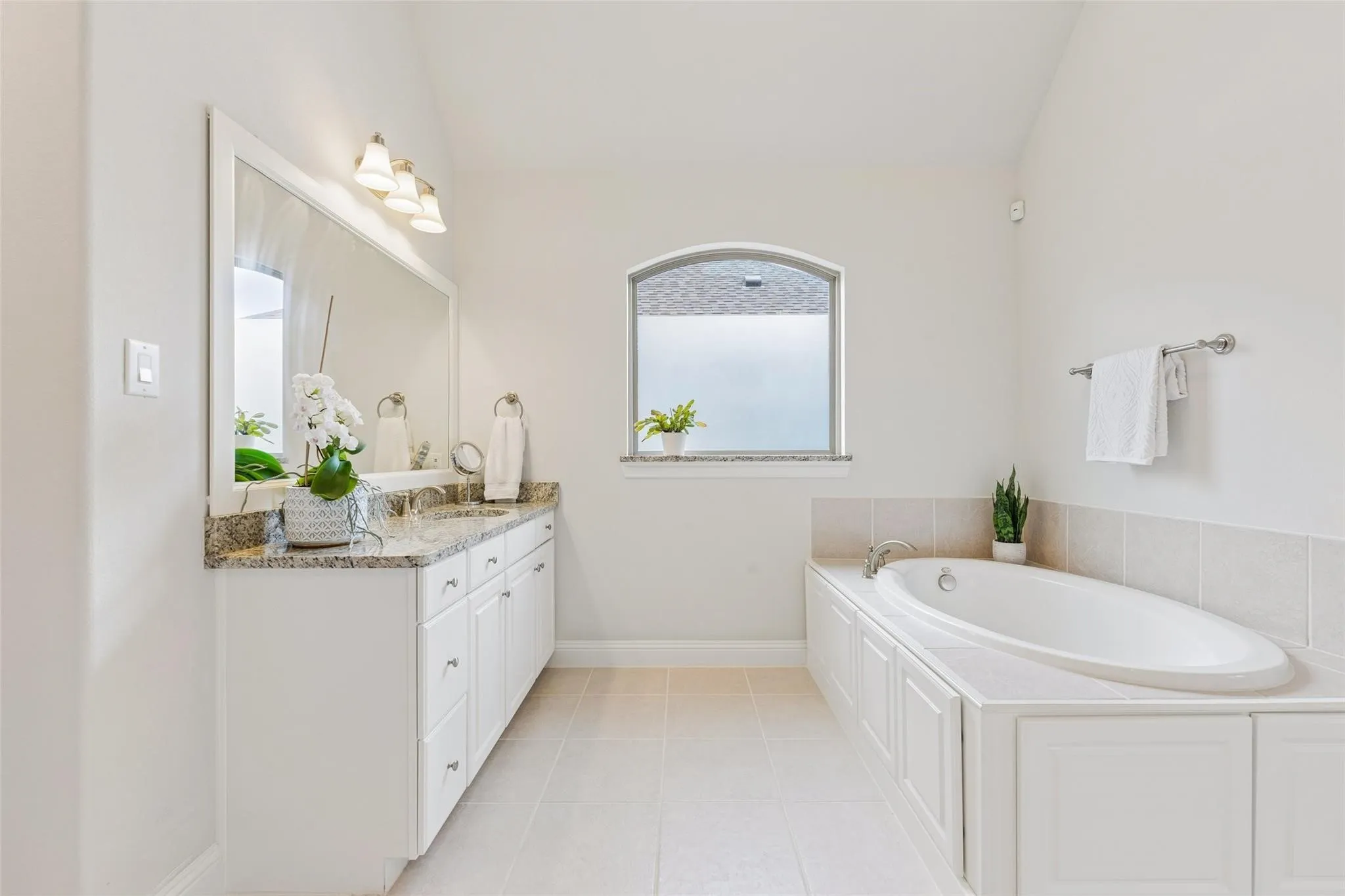 Dual vanity with granite countertop, undermount sinks, and ample storage cabinetry
