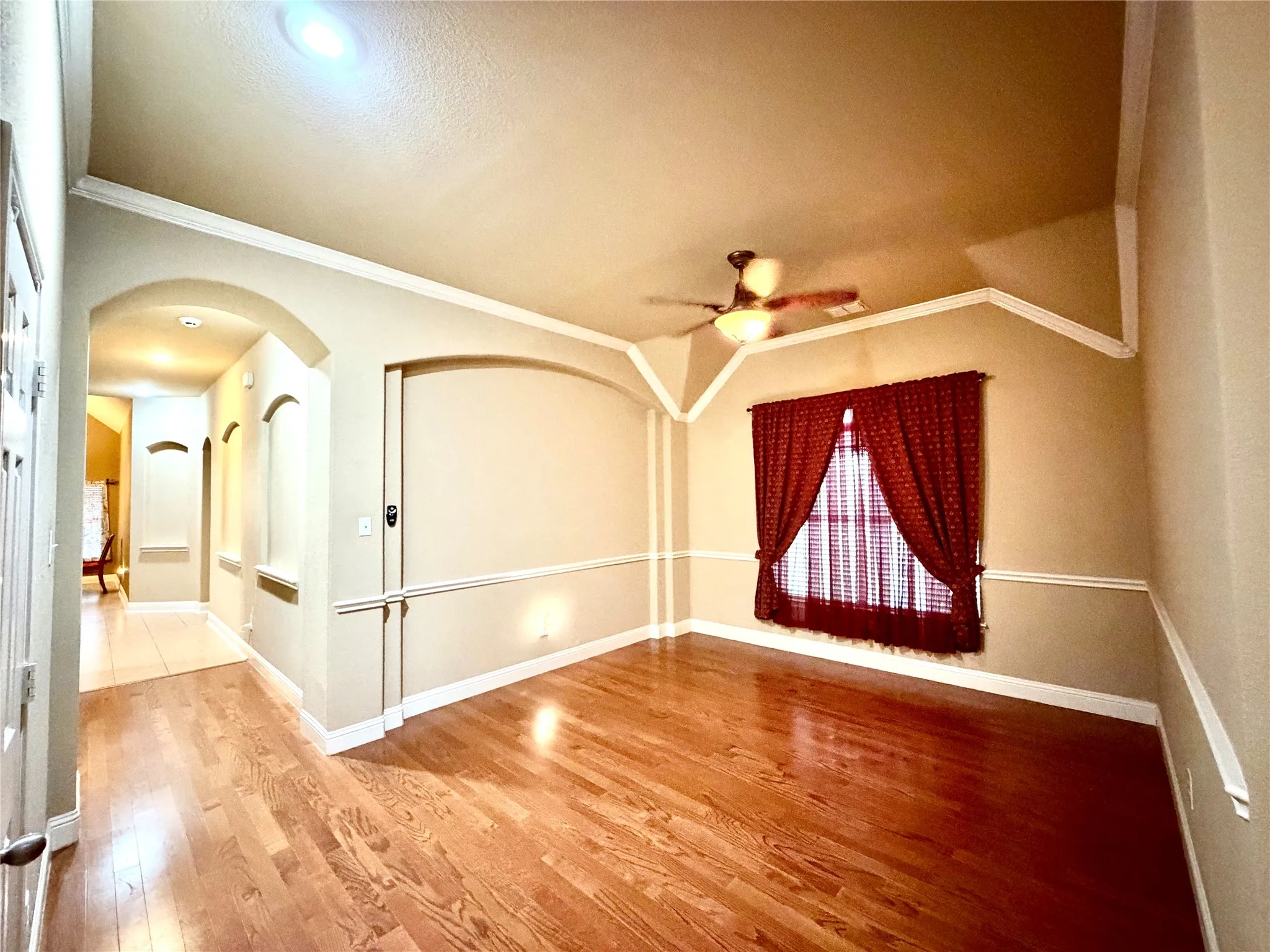 Hardwood-finish flooring, architectural archways, recessed lighting, crown molding, and a ceiling fan