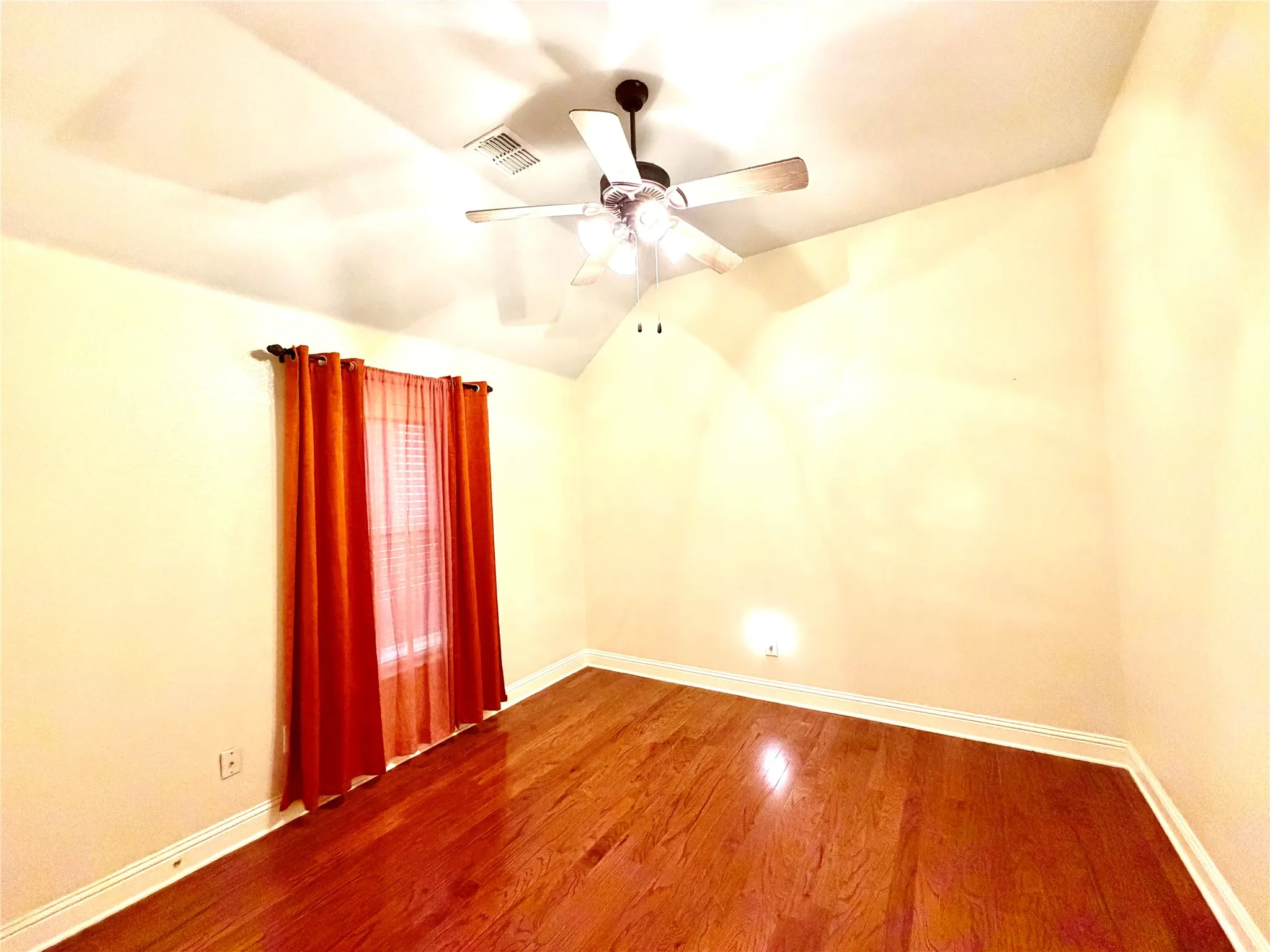Hardwood flooring, vaulted ceiling, and a ceiling fan with integrated lighting