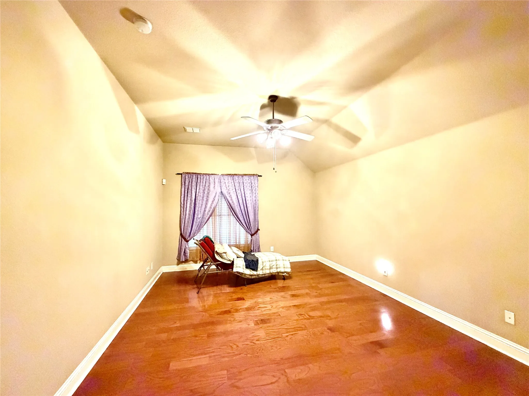 Varnished wood-finish flooring, vaulted ceiling, and recessed lighting