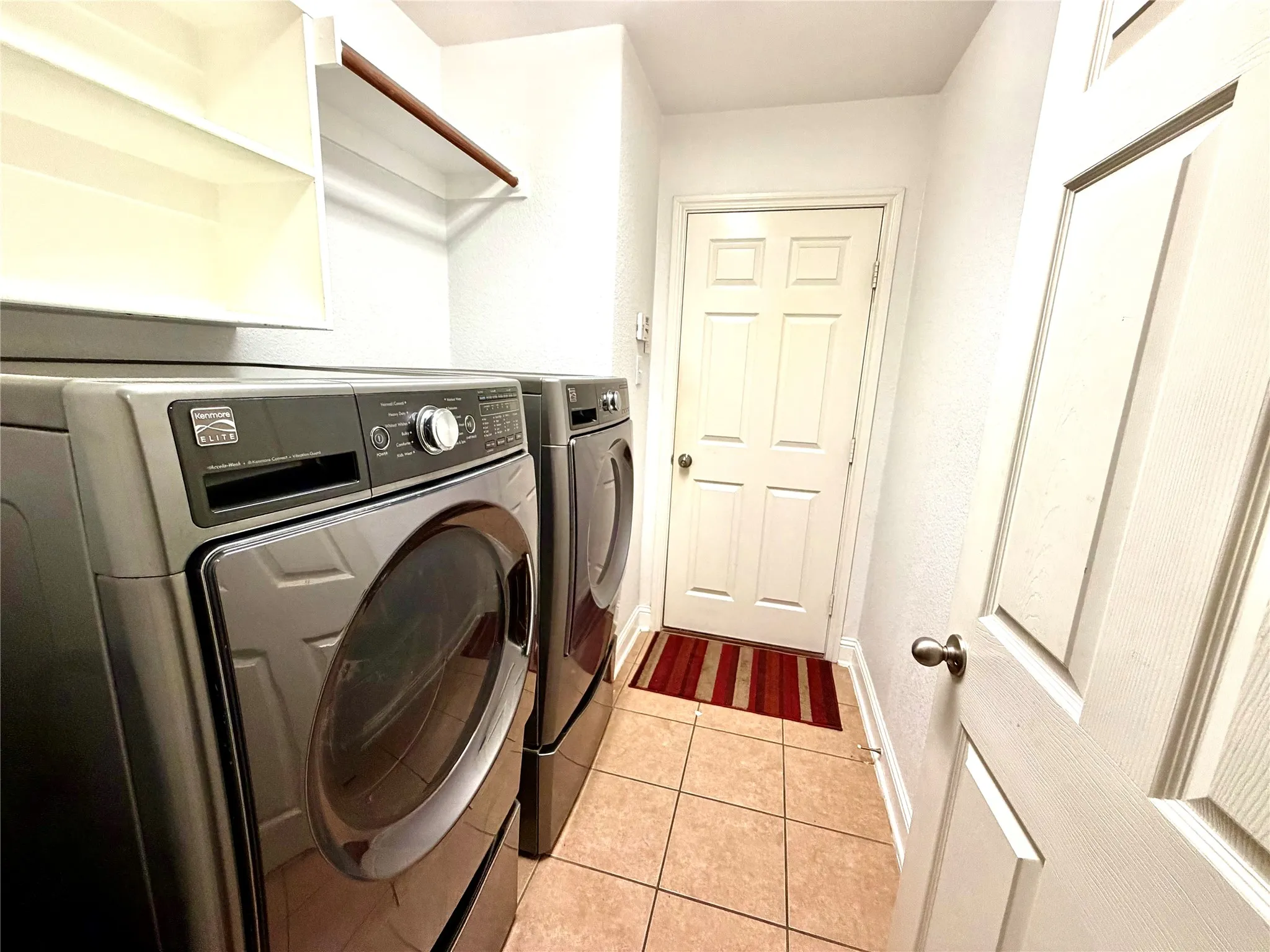 Built-in shelving, hanging rod, and tile flooring