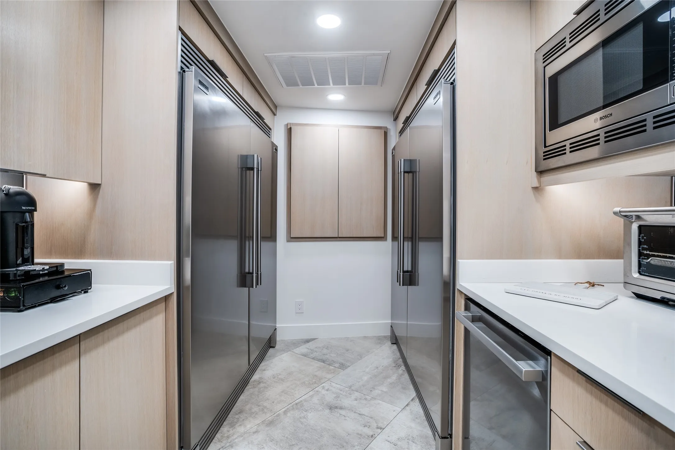 Butler's pantry has two sets of Frigidaire Professional refrigerator/freezers, a dishwasher, and a microwave