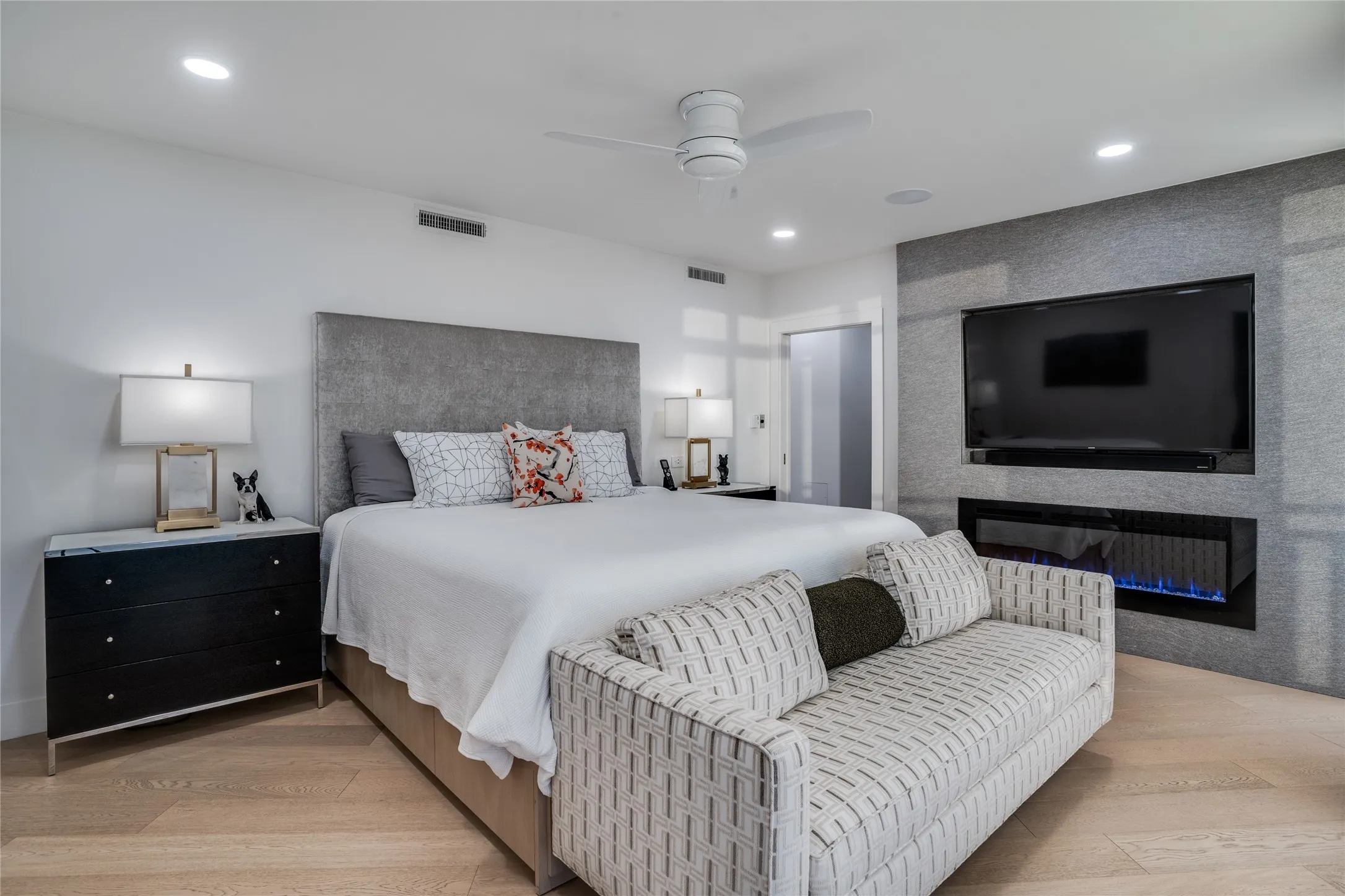 Primary bedroom w LED fireplace and white oak wood floors
