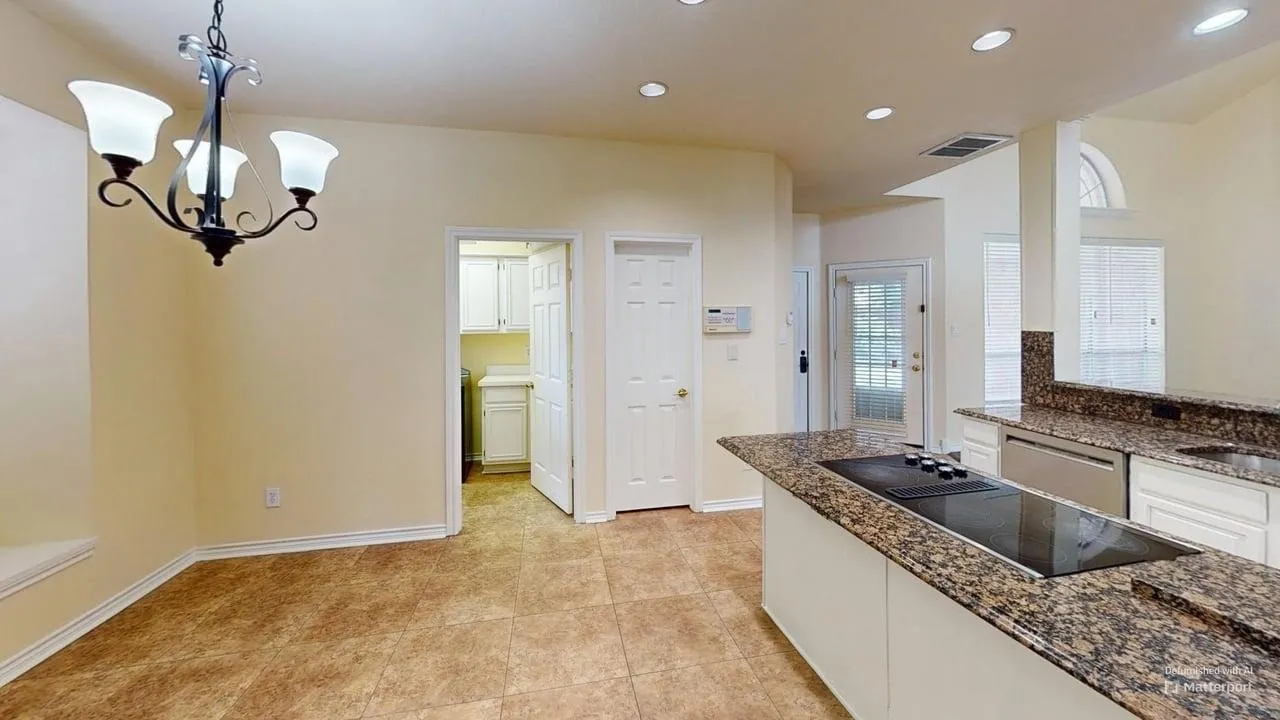 Tile flooring throughout, recessed lighting, and a kitchen island with a built-in cooktop