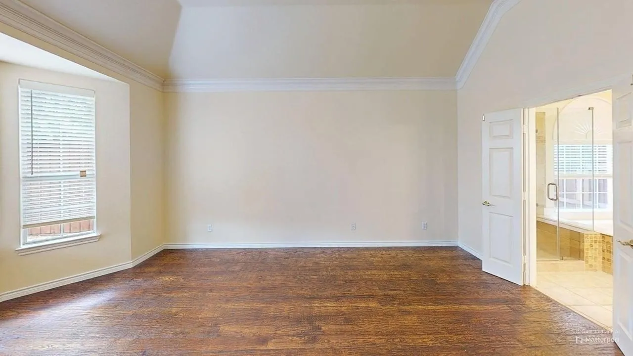 Vaulted ceilings, wood-finish flooring, crown molding, a bay window, and an en-suite bathroom with a glass-enclosed shower
