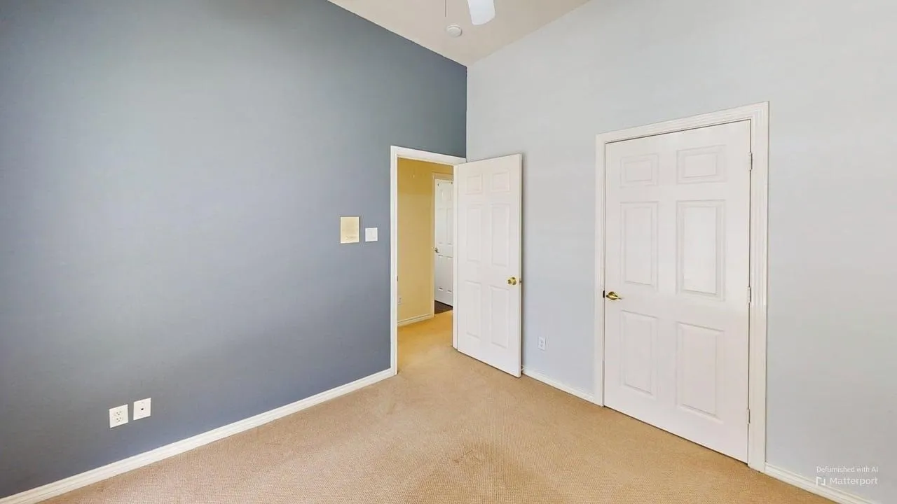 Vaulted ceiling with ceiling fan, carpet flooring, and white paneled doors