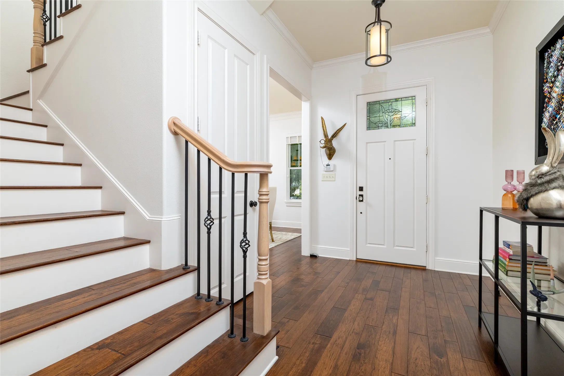 Hardwood flooring and staircase with wrought iron balusters