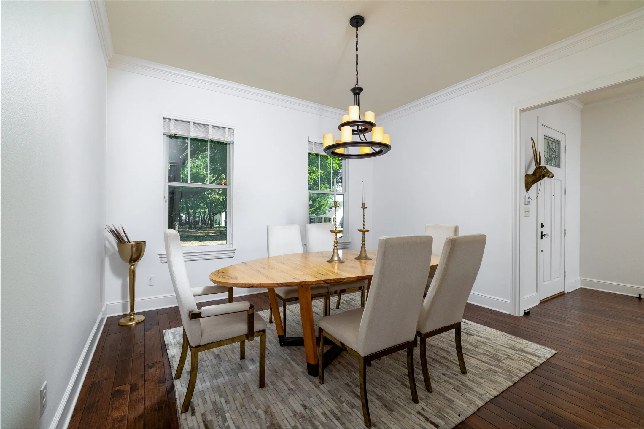 Hardwood flooring, crown molding, double hung windows, and a chandelier with candelabra-style lights