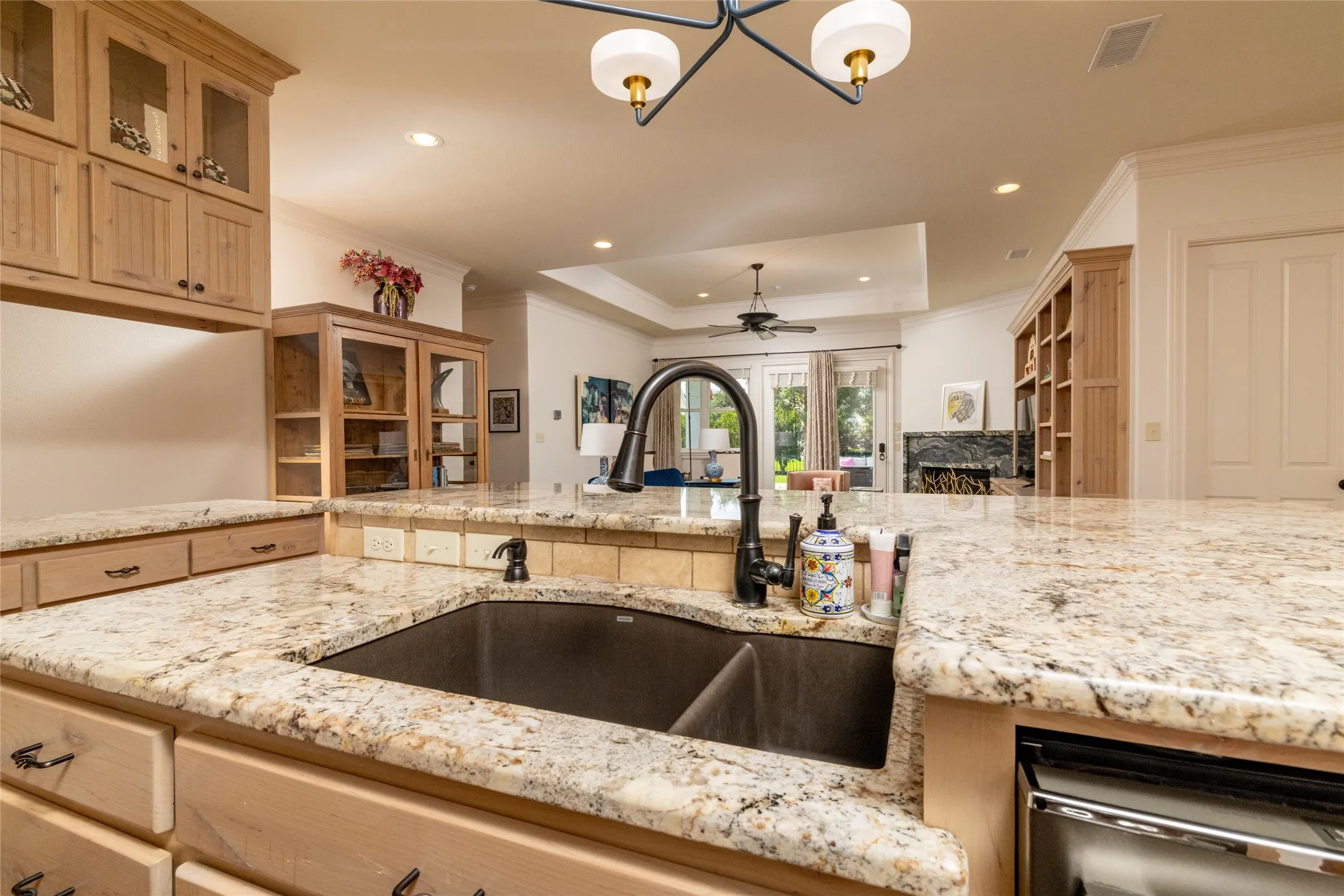 Kitchen featuring light-toned cabinetry, granite countertops, a built-in double sink, and a black gooseneck faucet