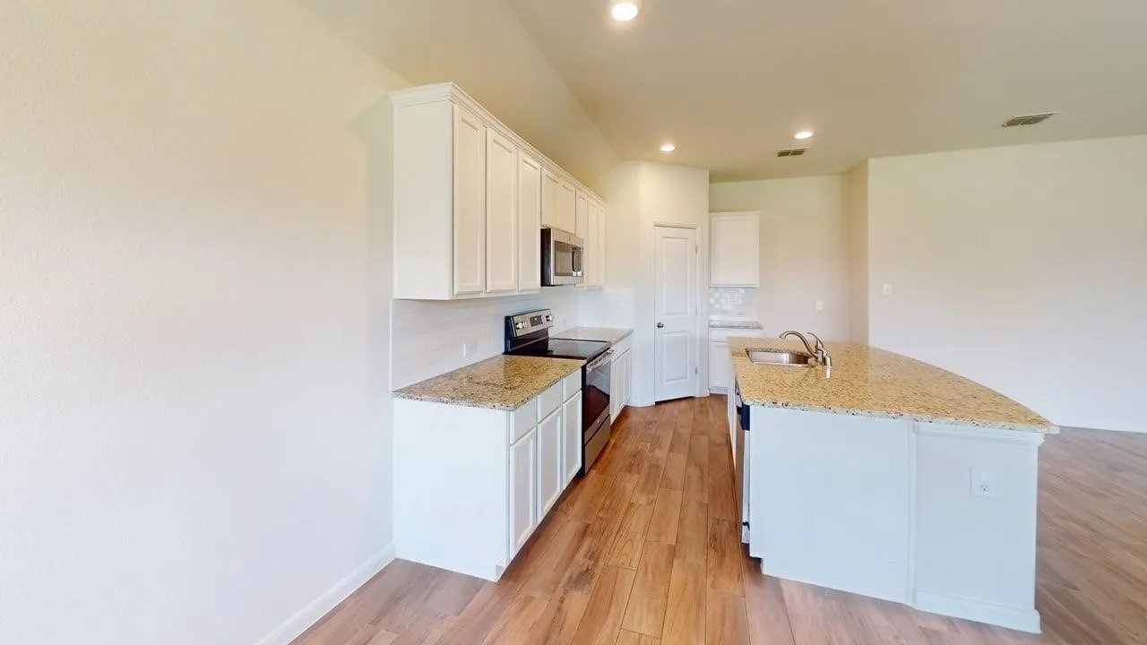 Kitchen featuring wood-finish flooring, white cabinetry, a kitchen island with sink, stainless steel appliances, and light-toned countertops