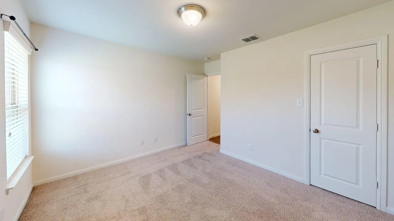 Neutral tone wall paint, carpet flooring, a window with horizontal blinds, and a flush mount ceiling light