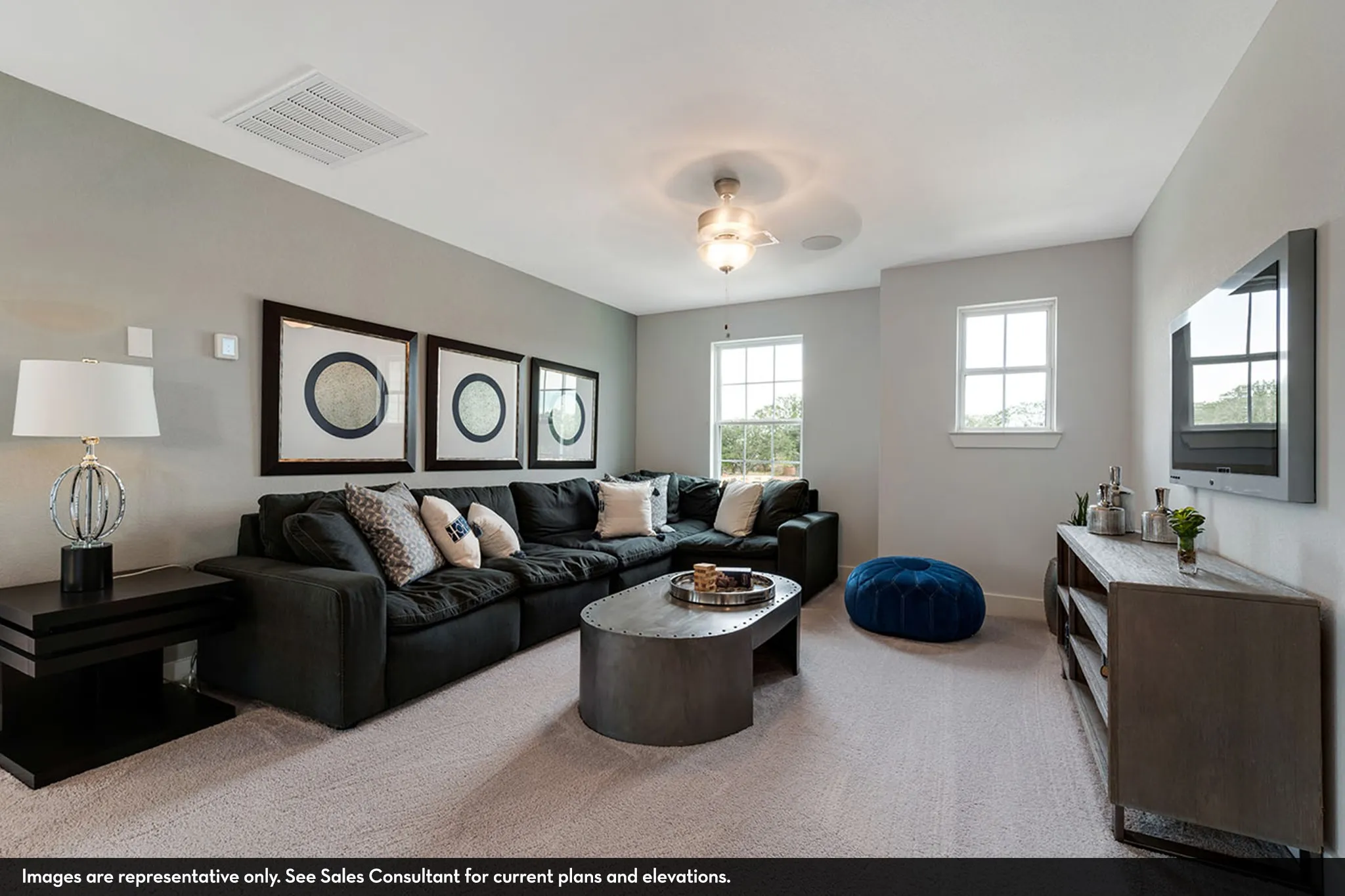 Bright room with light grey wall paint, two windows for natural light, and a ceiling fan with integrated lighting