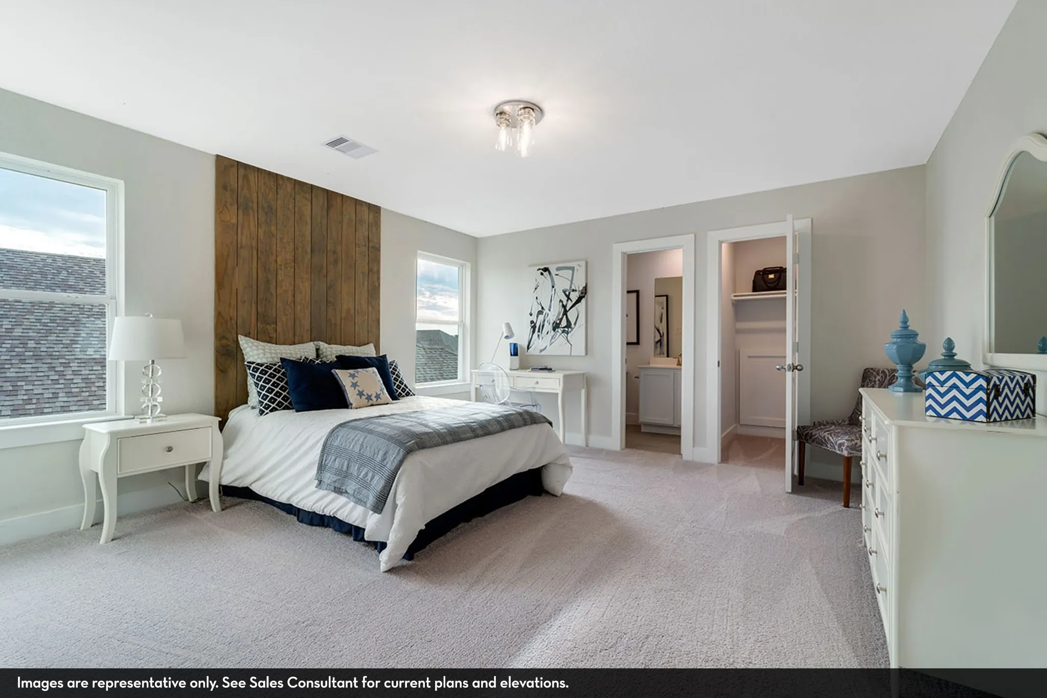 Recessed lighting, wood-paneled accent wall, dual windows, carpeted flooring, and an adjoining bathroom