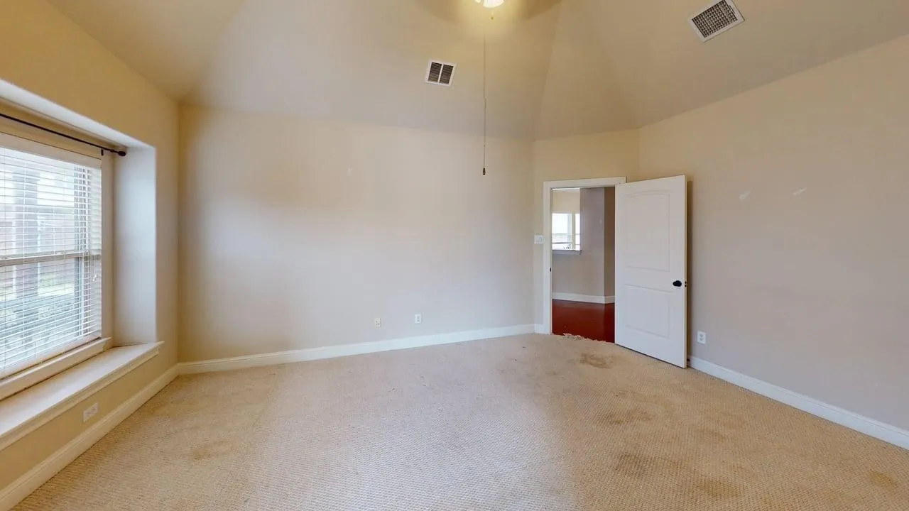 Vaulted ceiling, ceiling fan, carpeting, window with blinds, panel door