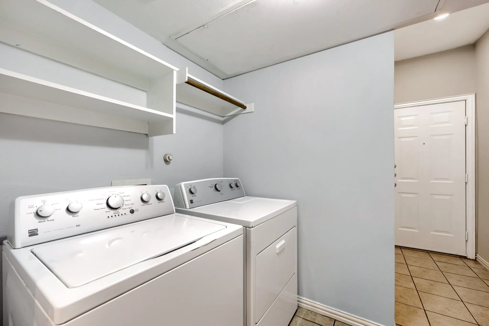 Laundry area featuring built-in shelving and a clothes hanging rod
