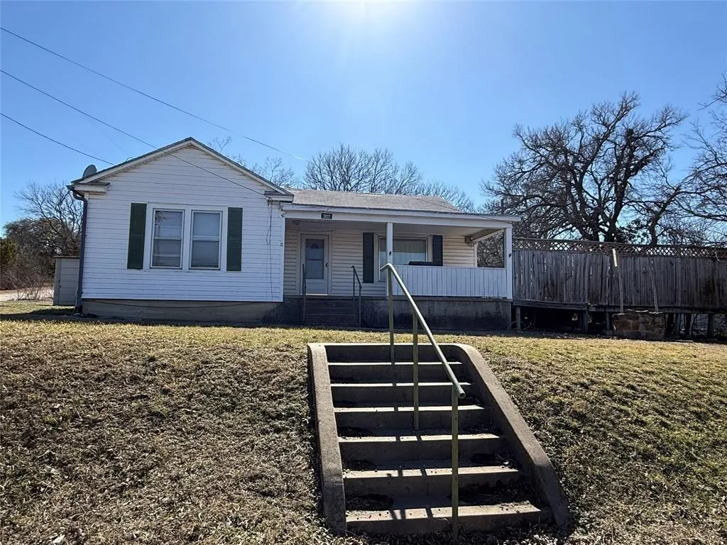 White siding exterior with a covered porch and concrete steps