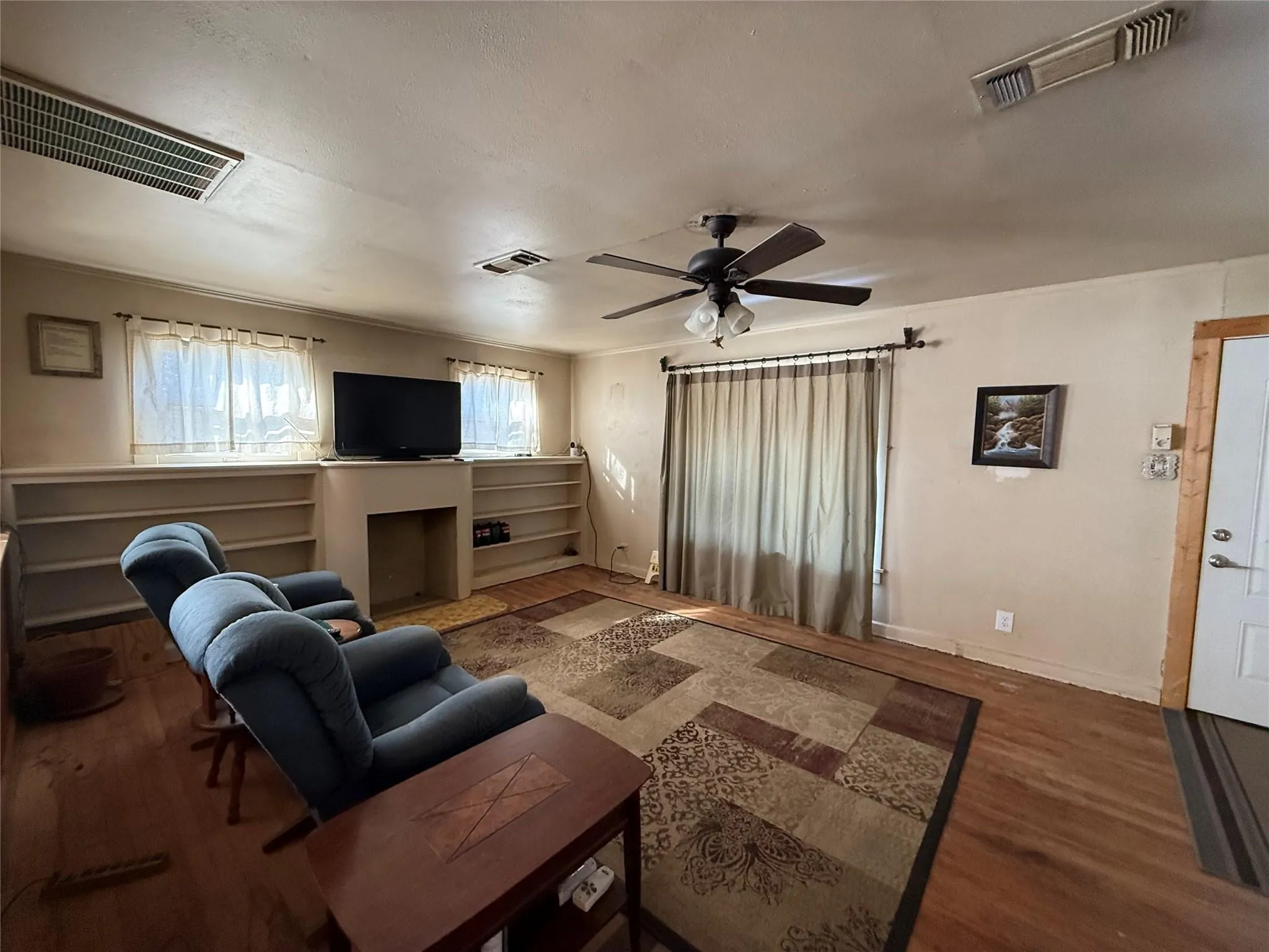Wood-finish flooring throughout, complemented by a ceiling fan with integrated lighting