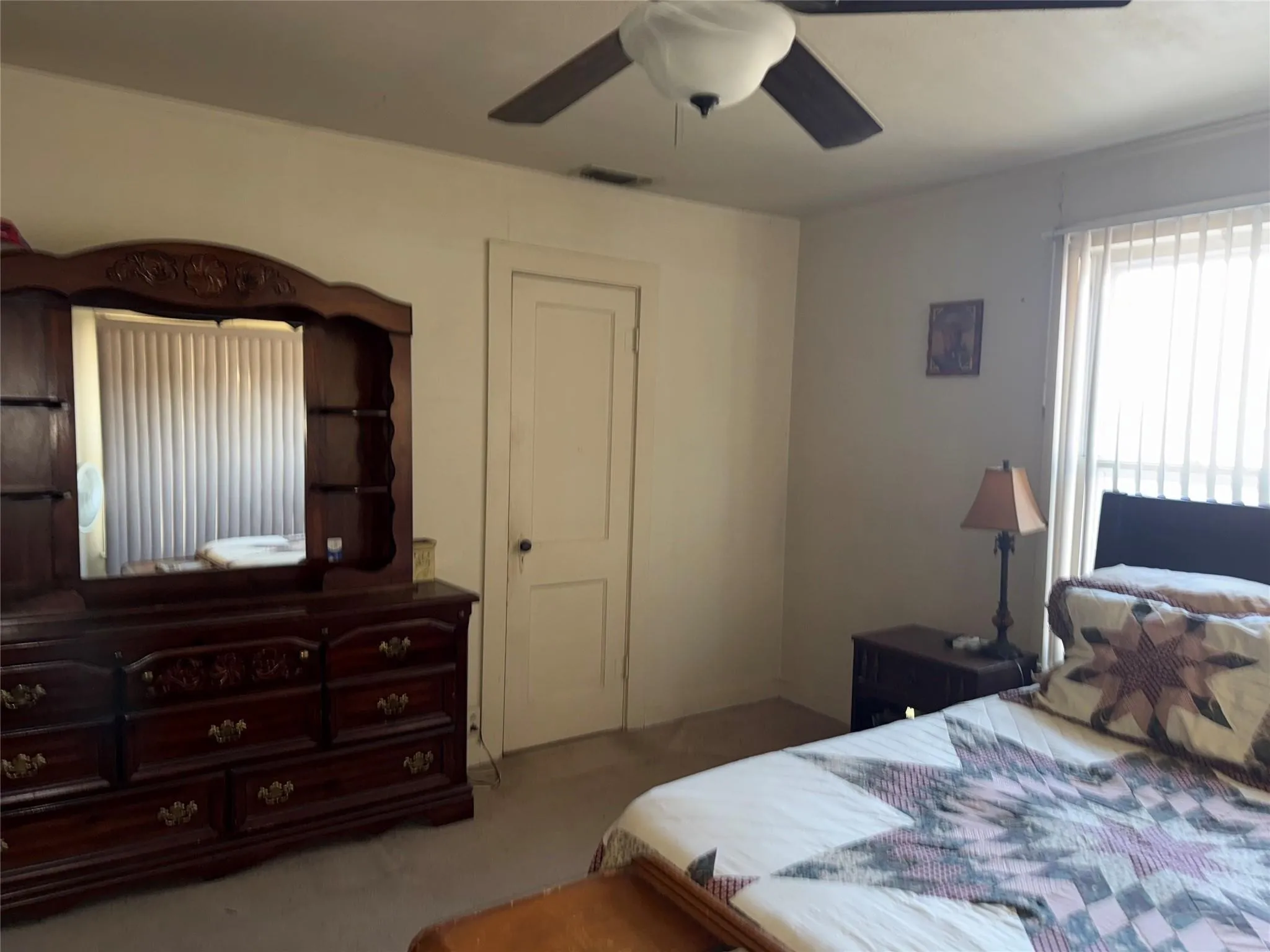 Ceiling fan with integrated lighting, wall-to-wall carpeting, and window with vertical blinds