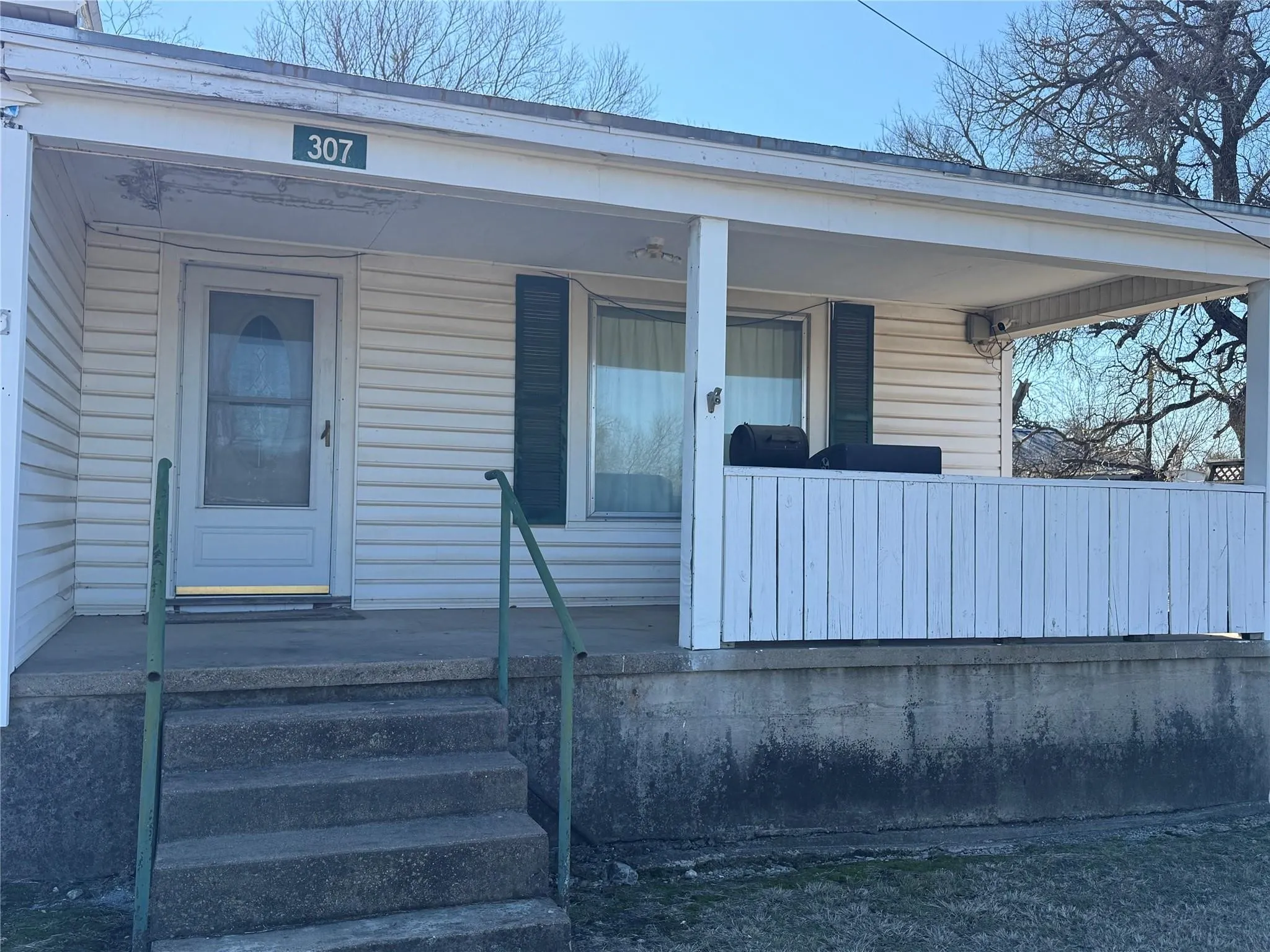 Covered front porch with white siding exterior