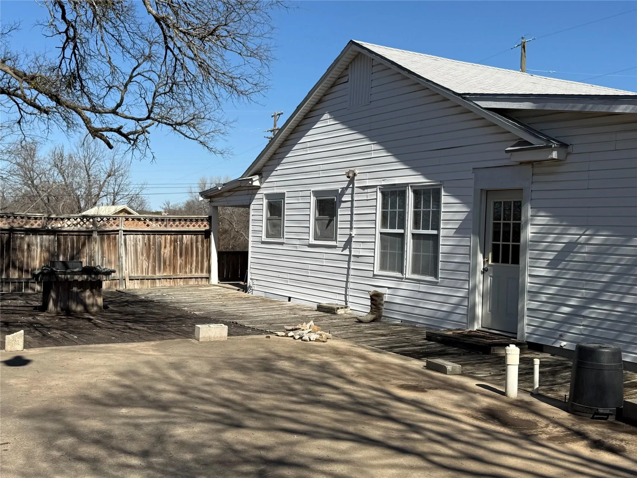 White siding exterior with multiple windows and a glass-paneled door