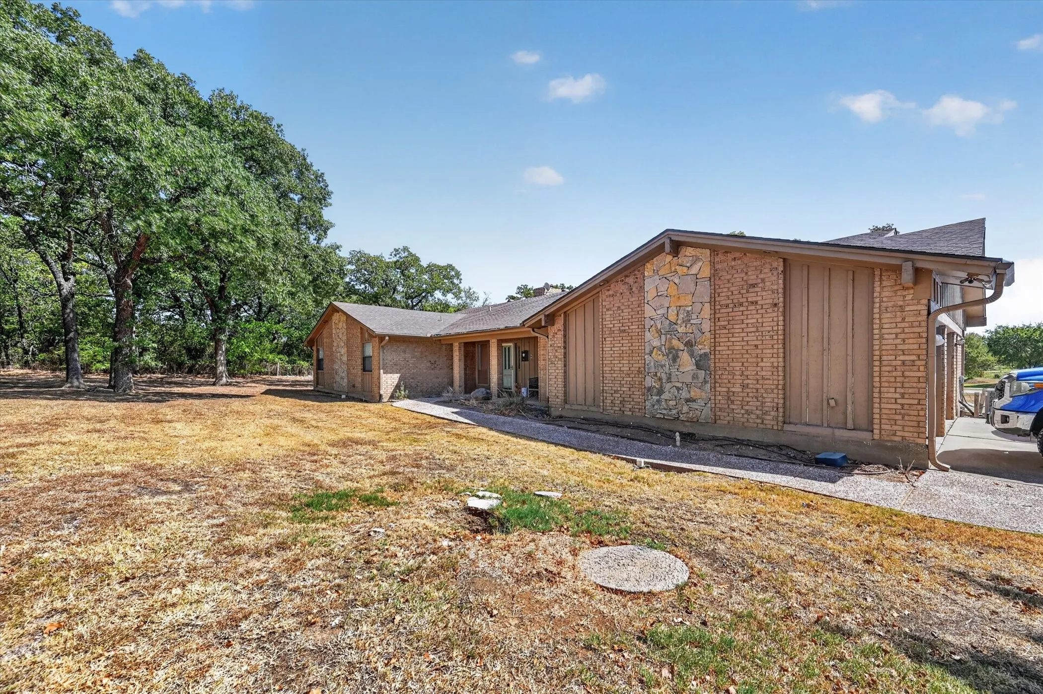 Exterior view of the existing residence surrounded by mature trees.