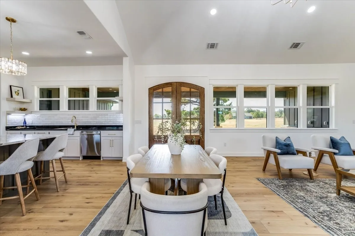 Open-concept living space with wood-finish flooring, recessed lighting, and expansive windows