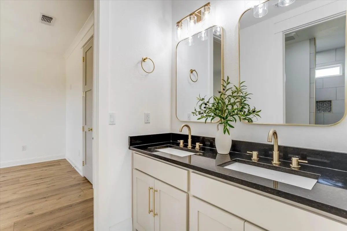 Dual vanity with undermount sinks and brass-finish fixtures