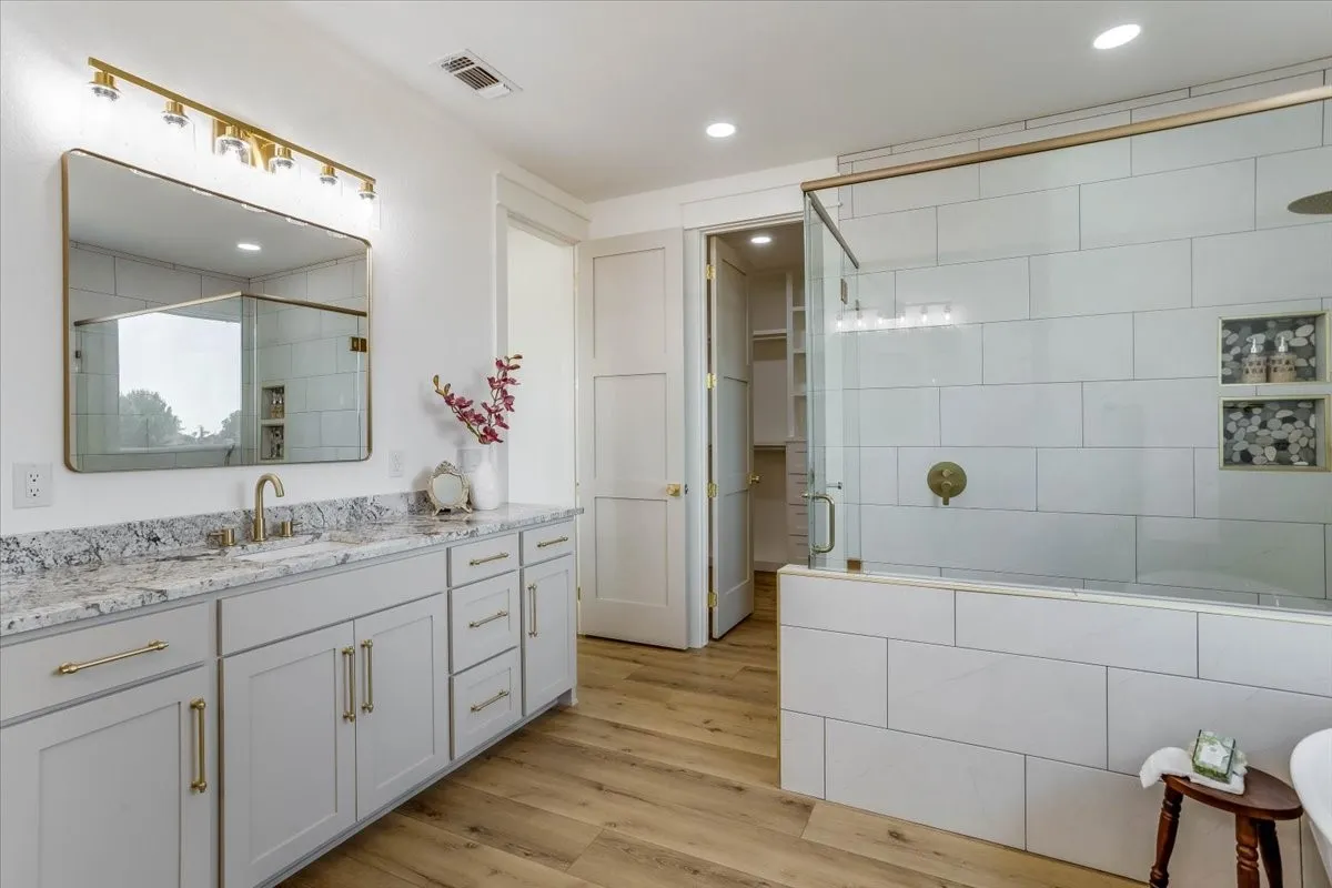 Dual vanity with light-toned cabinetry and stone countertops