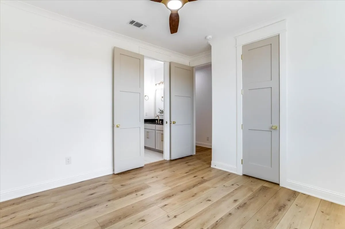 Wood-finish flooring throughout, white crown molding, and recessed lighting