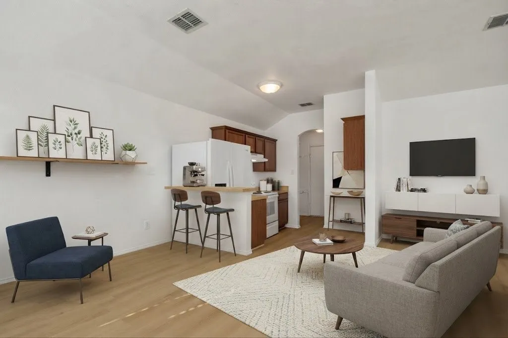 Open-concept living area with wood-finish flooring, vaulted ceiling, and recessed lighting