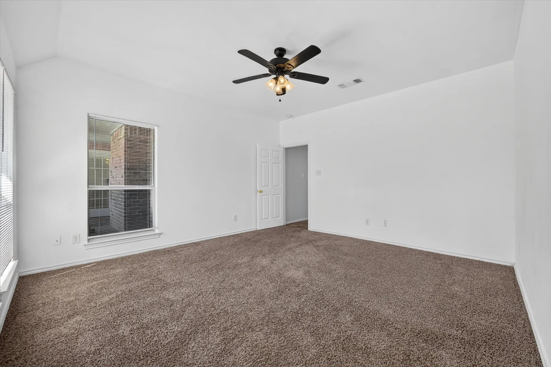 Vaulted ceiling with an attached ceiling fan and light fixture