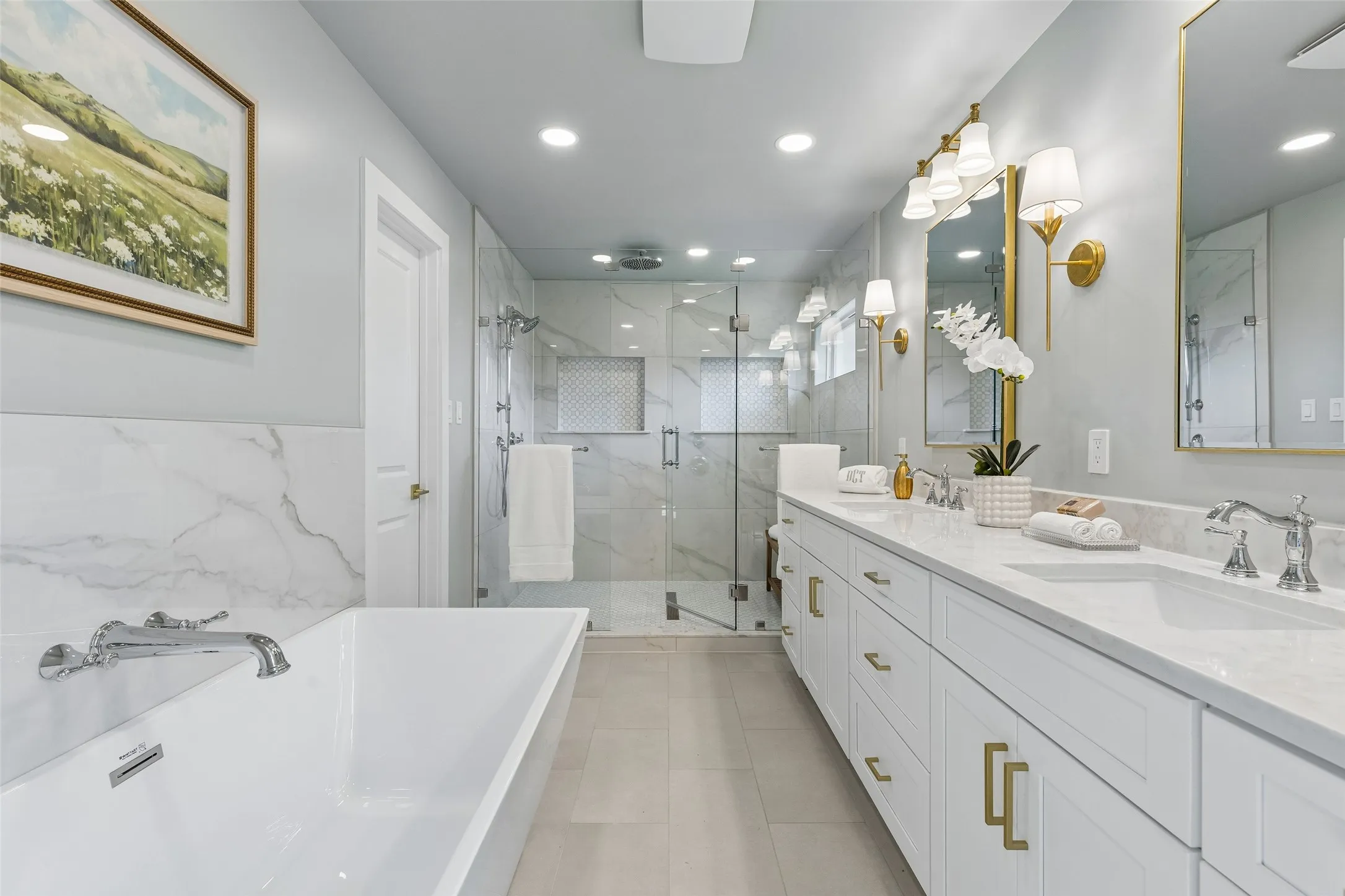 Updated primary bath with dual sinks, a freestanding tub and an oversized frameless glass shower with dual showerheads.