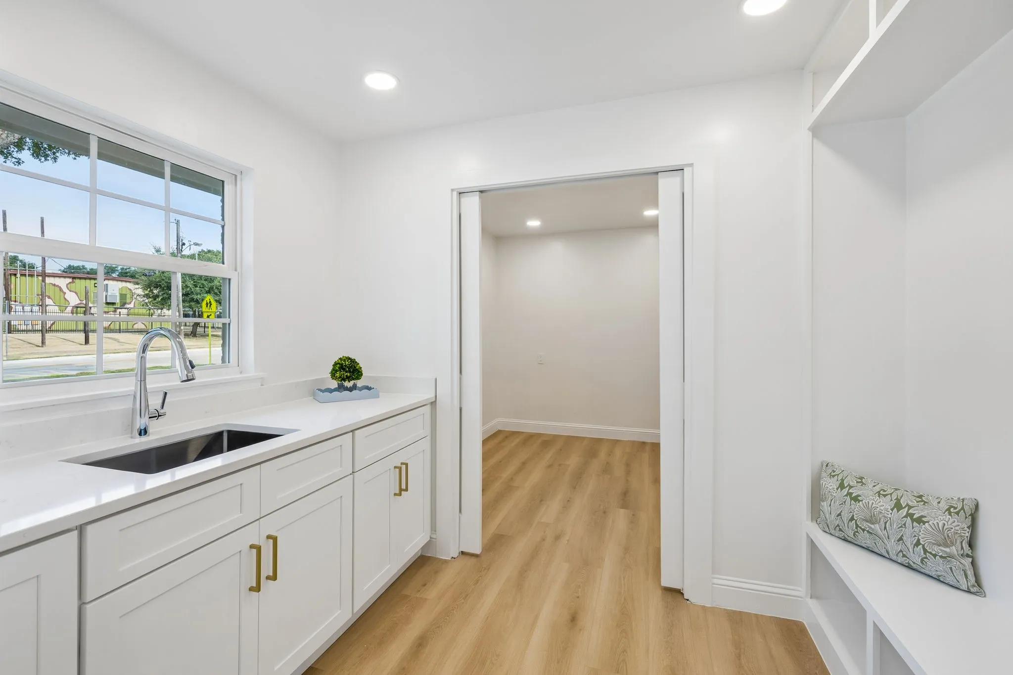 Spacious utility room with mud area, sink and addtional storage.