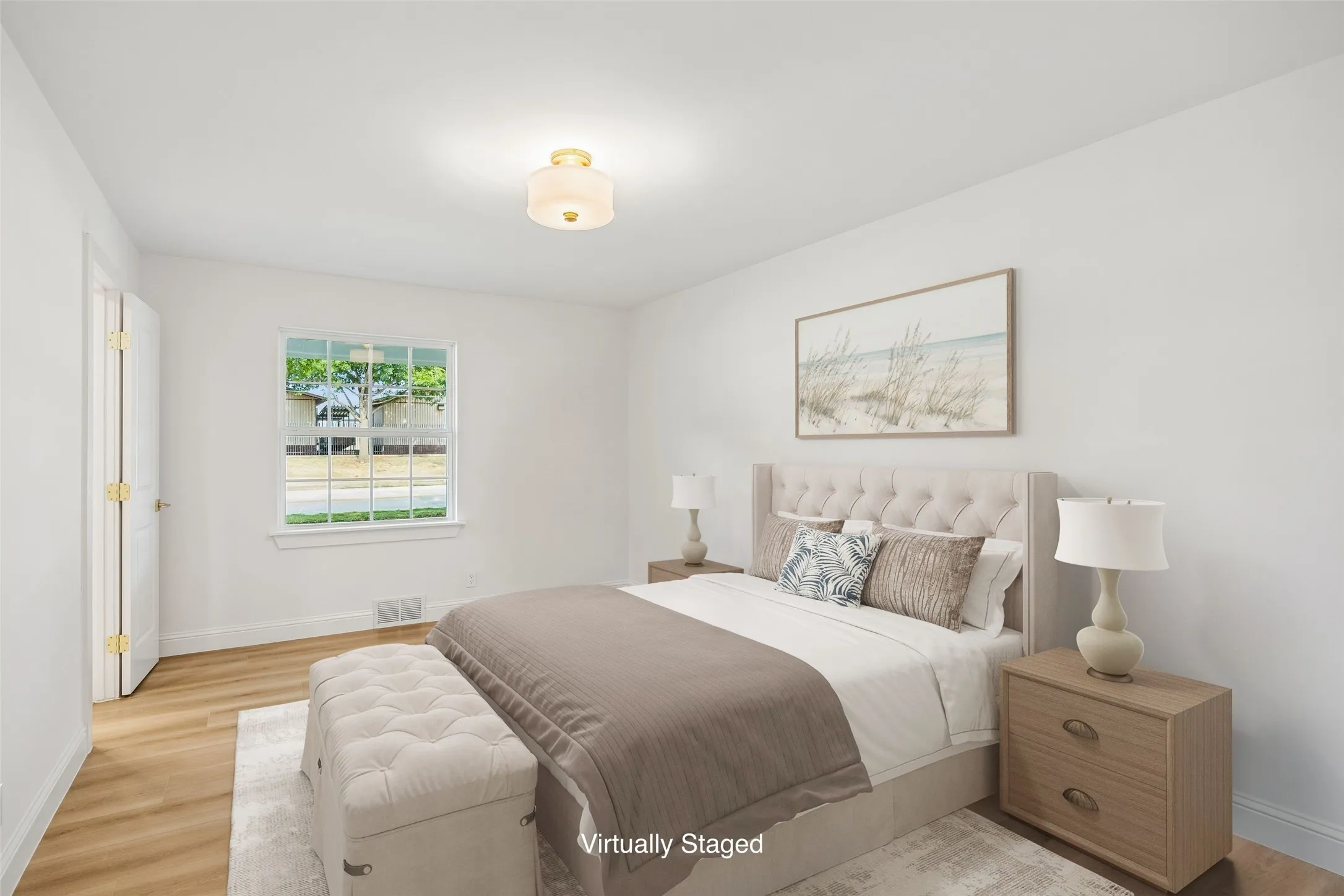 Bedroom connected to a Jack and Jill bath with LVT floors and a large window bringing lots of natural light.