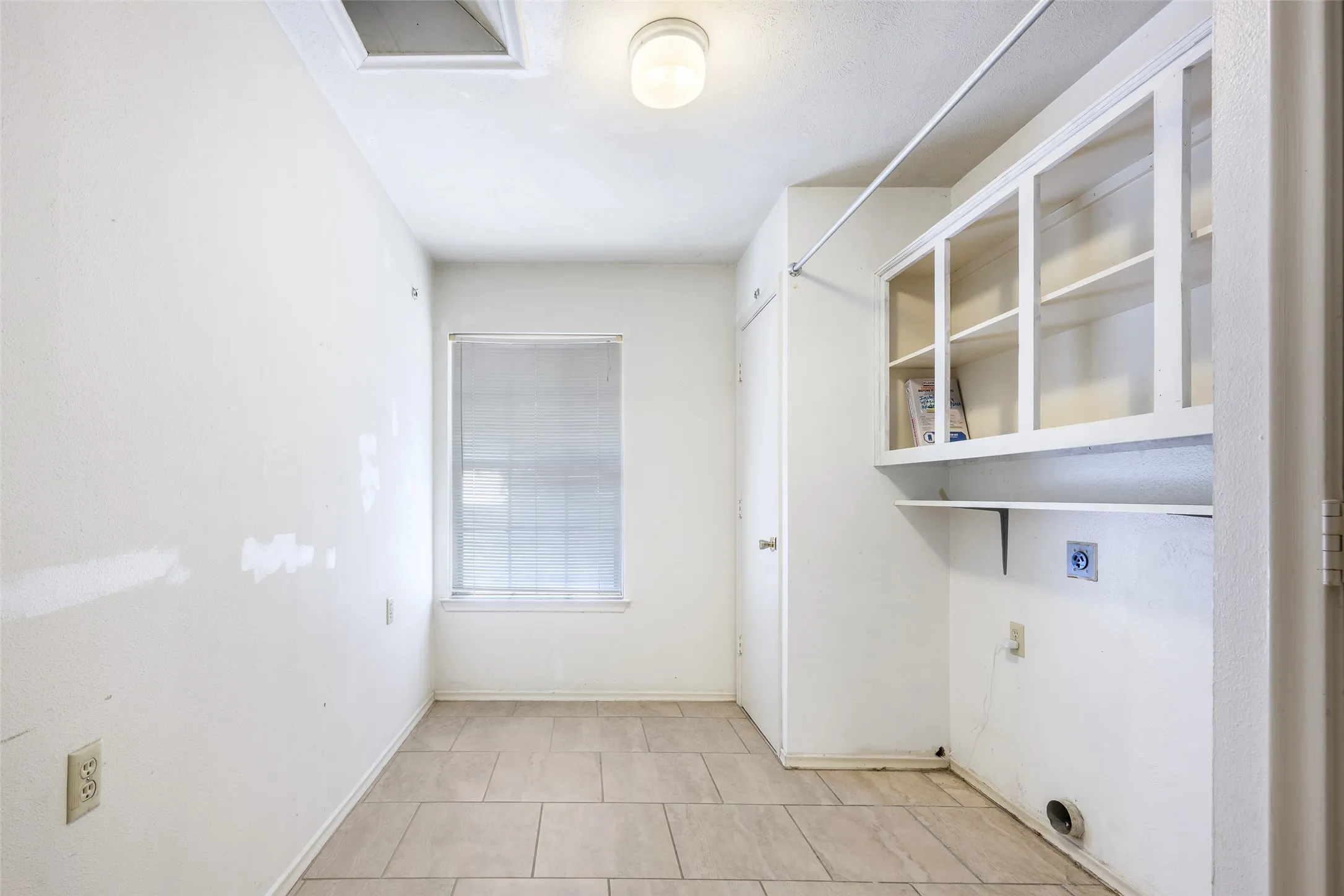Ceramic tile flooring, built-in upper cabinetry, and a ceiling-mounted light fixture
