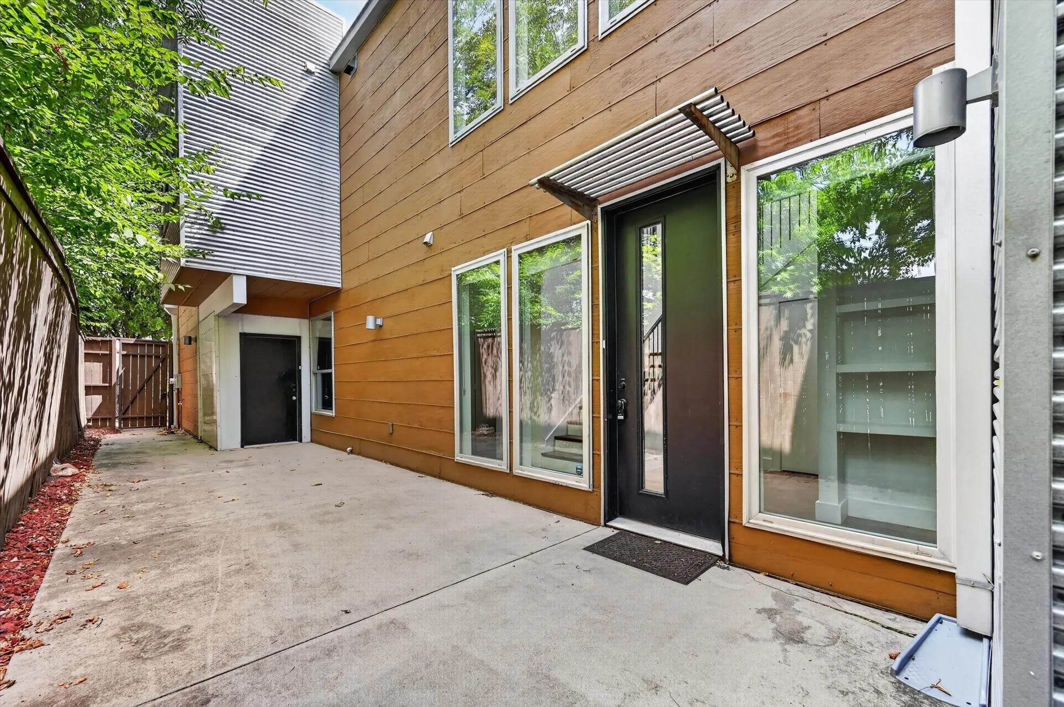 Exterior featuring a concrete patio, wood siding, and multiple windows