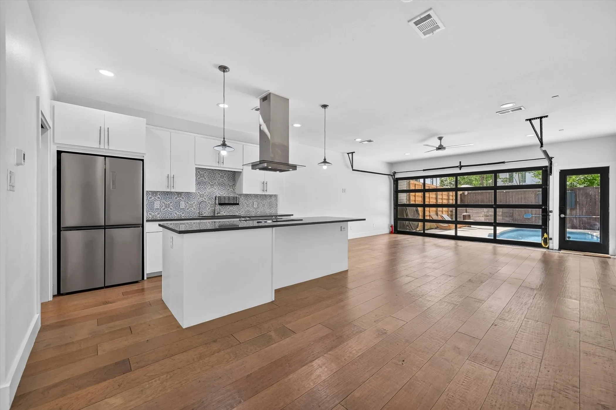 Open-concept living area featuring wood-finish flooring and recessed lighting