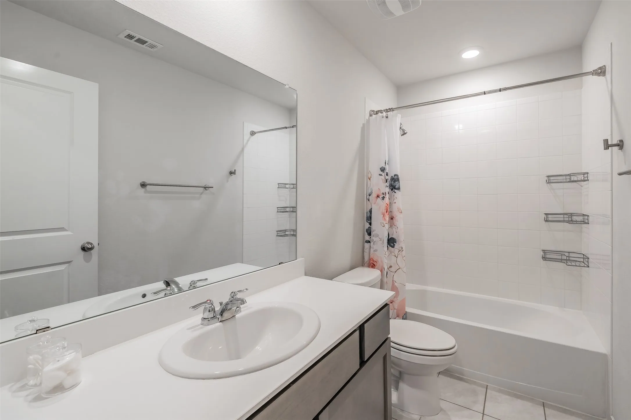 White vanity with an integrated sink, polished chrome faucet, and expansive wall-mounted mirror