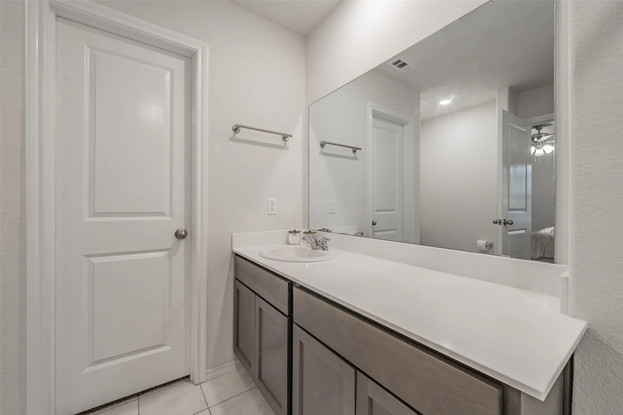 Vanity with a single undermount sink, expansive countertop, and wood-finish cabinetry
