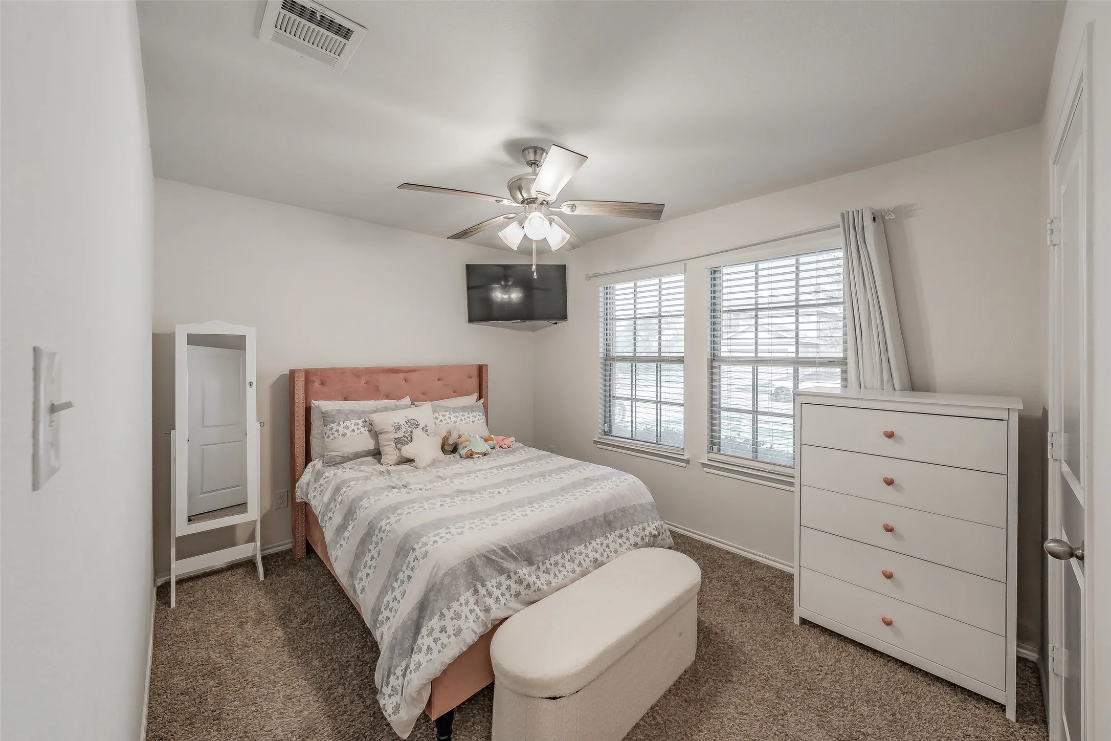 Carpet flooring, dual windows with blinds, and a ceiling fan with integrated lighting