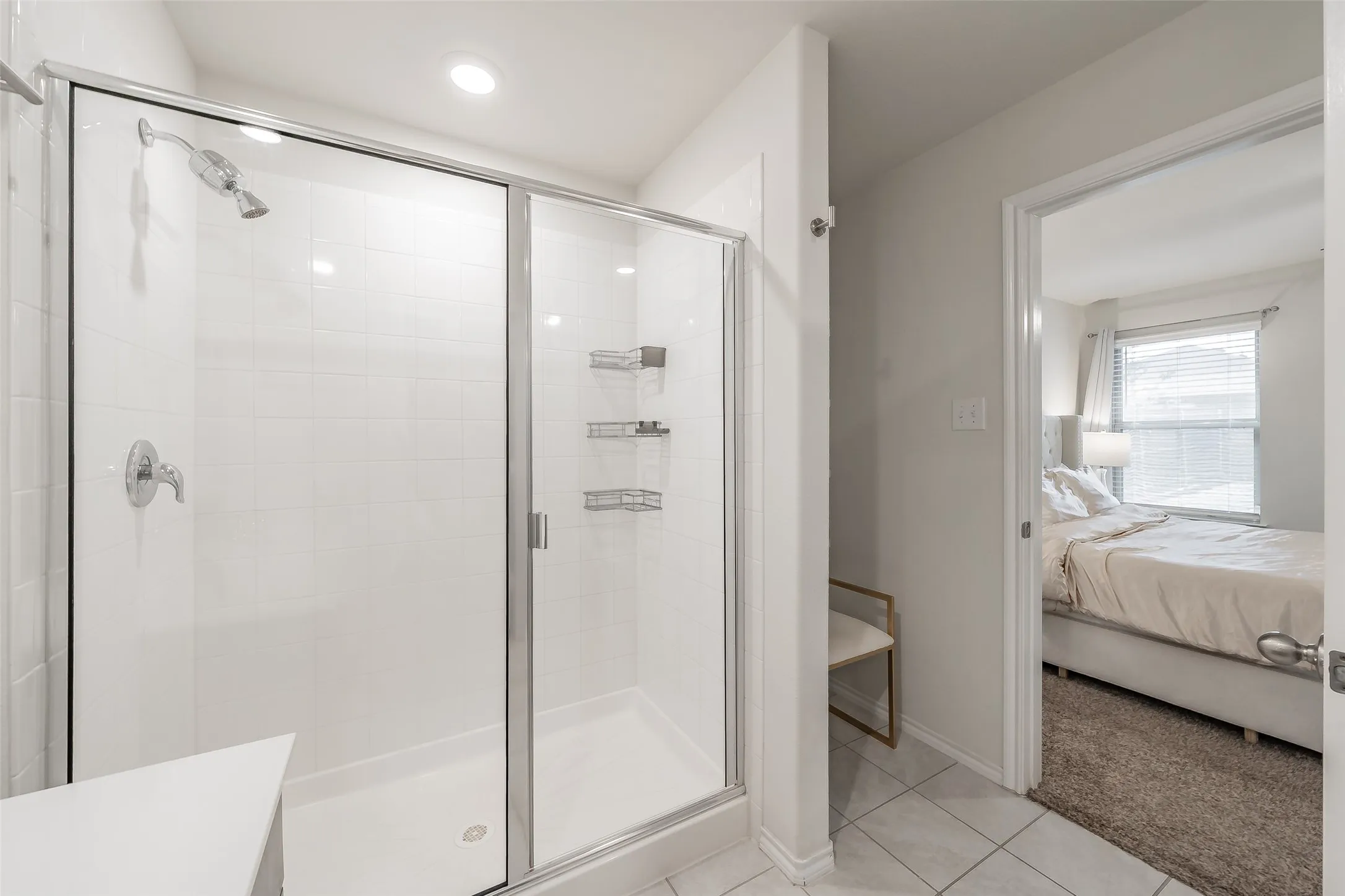 Walk-in shower with clear glass enclosure and chrome fixtures