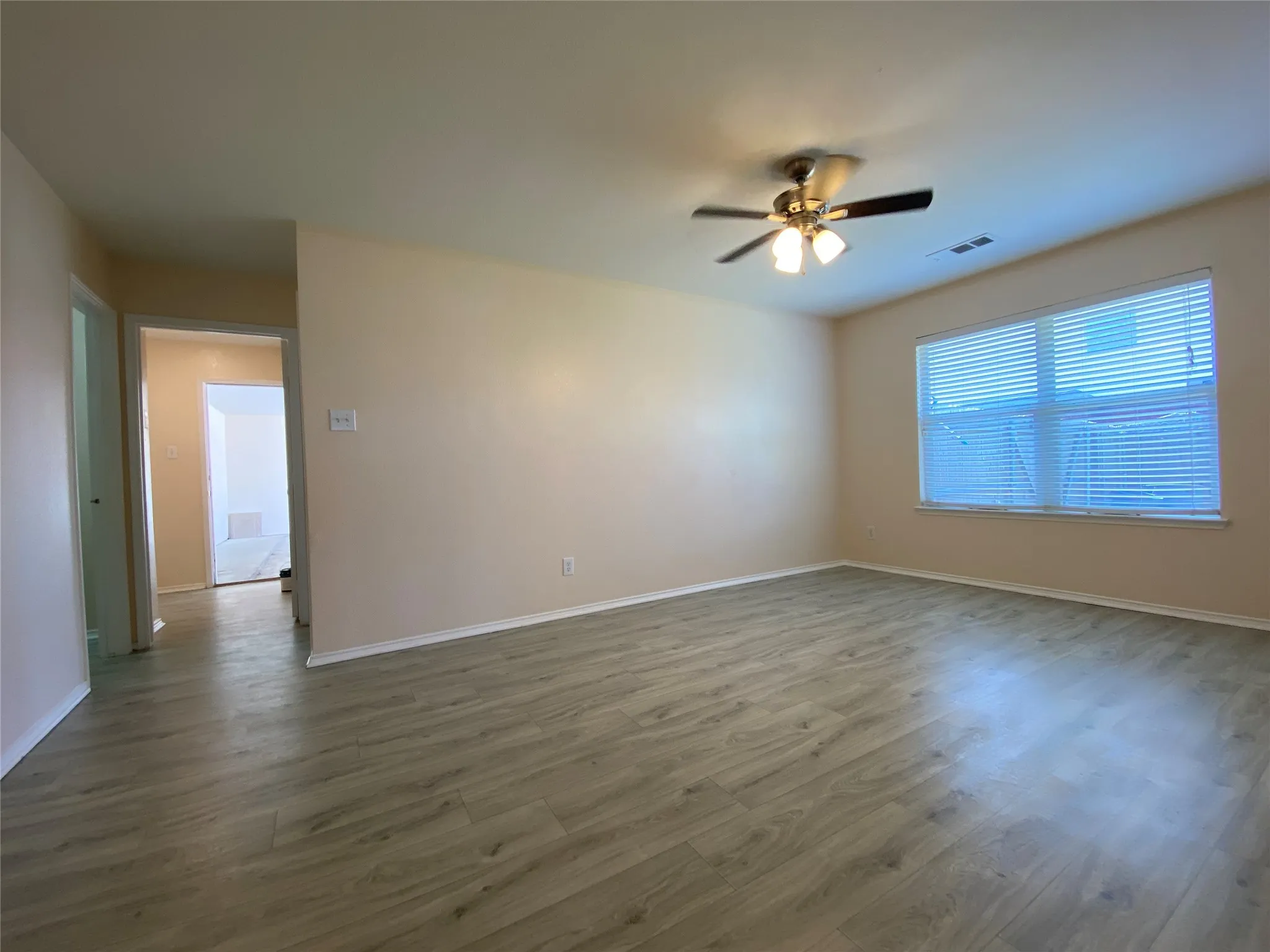 Unfurnished room with dark wood finished floors, baseboards, visible vents, and a ceiling fan