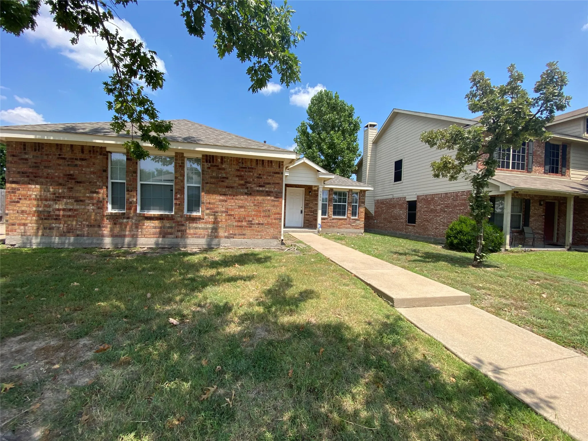View of front facade featuring brick siding and a front yard