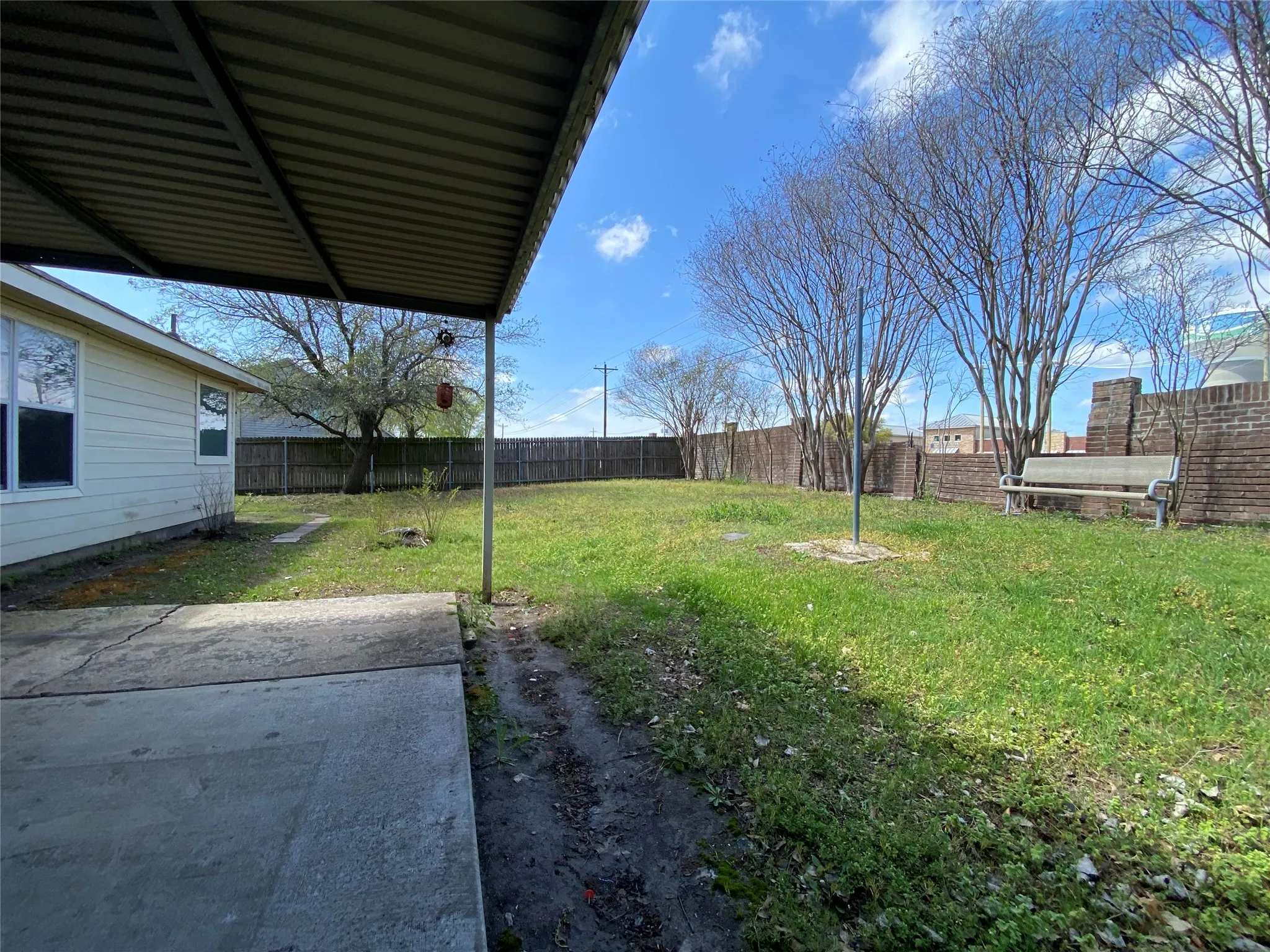 View of yard featuring fence and a patio