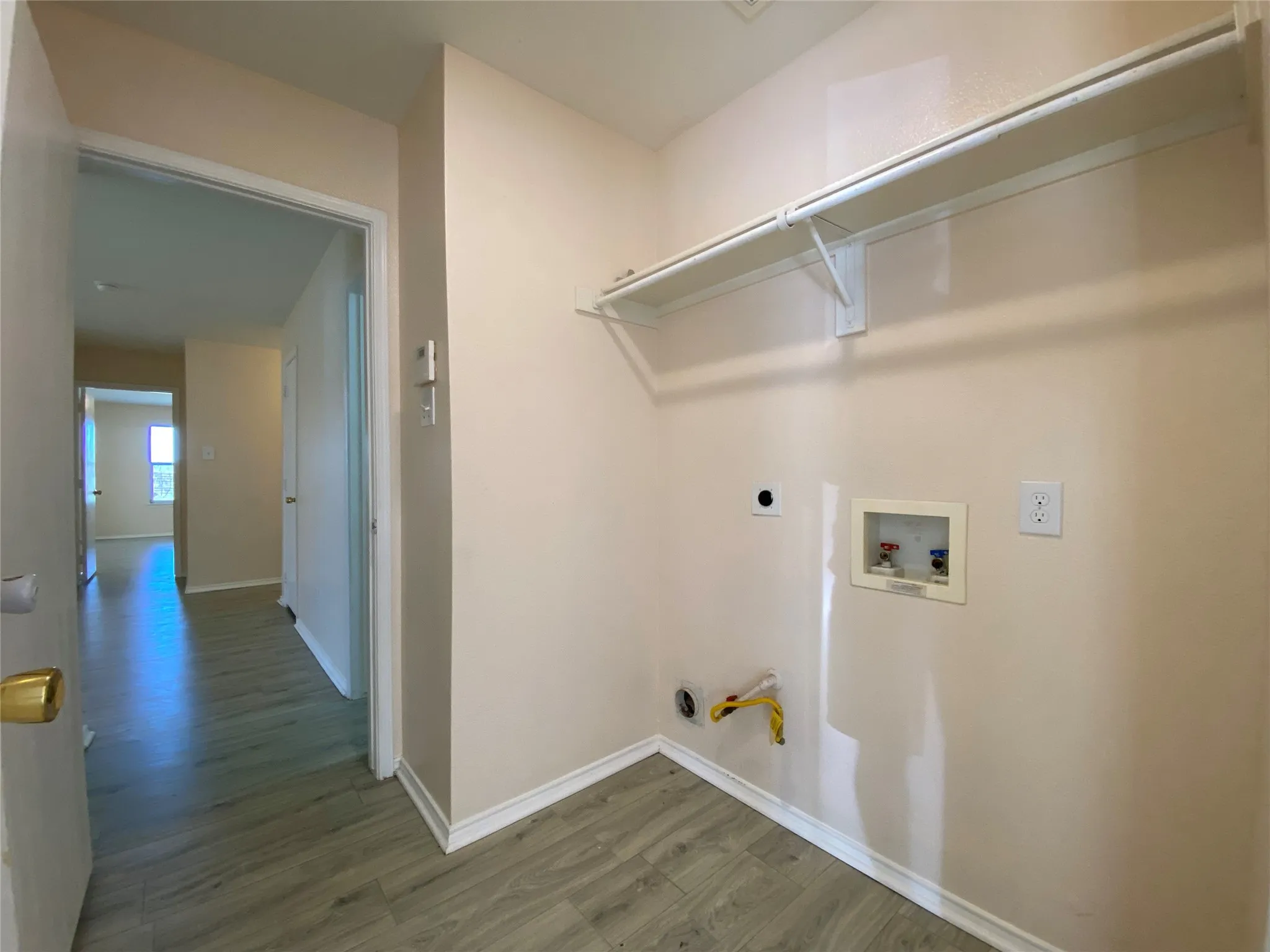 Washroom featuring hookup for a washing machine, baseboards, wood finished floors, laundry area, and hookup for an electric dryer